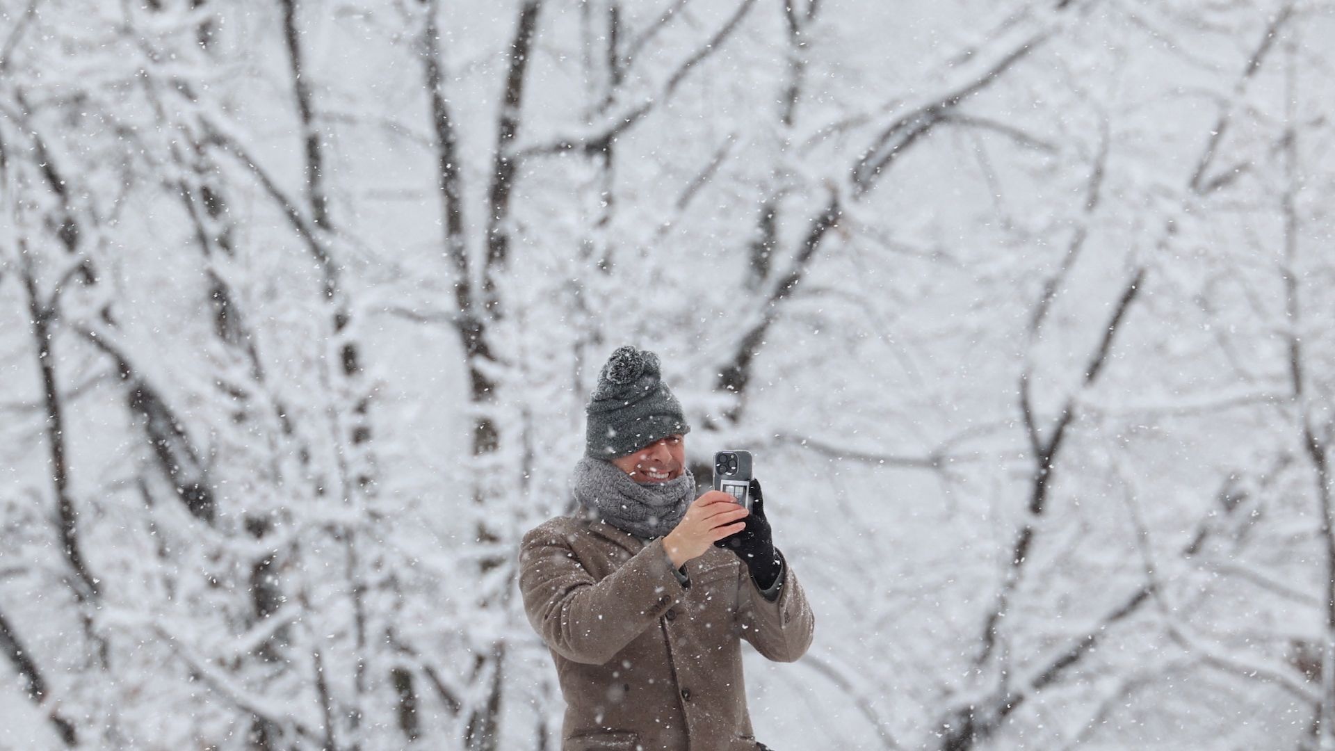 Man takes a picture in Central Park as snow continues to fall on Feb. 13. 