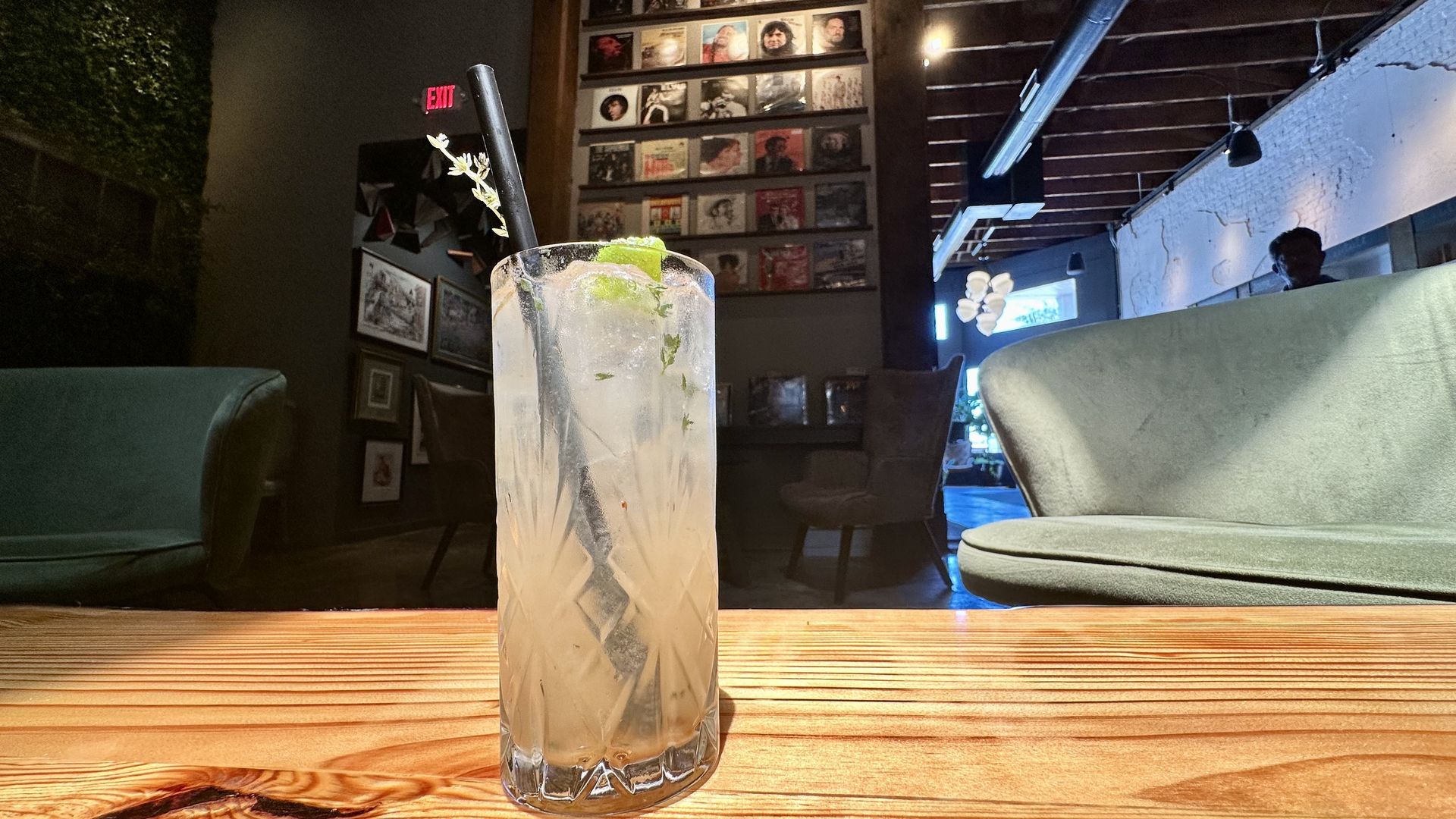 A photo of a cocktail with records stacked in the background