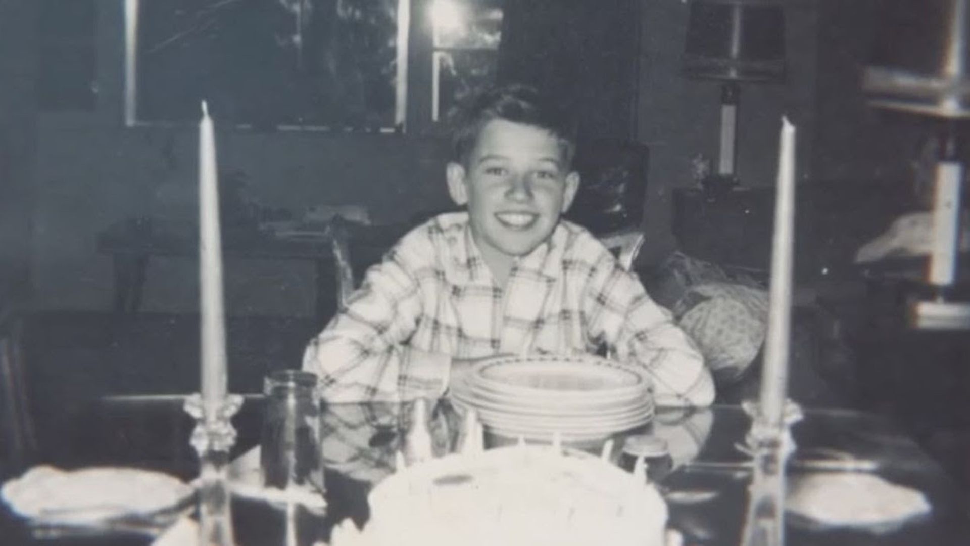 A young Joe Biden smiling at a dinner table 