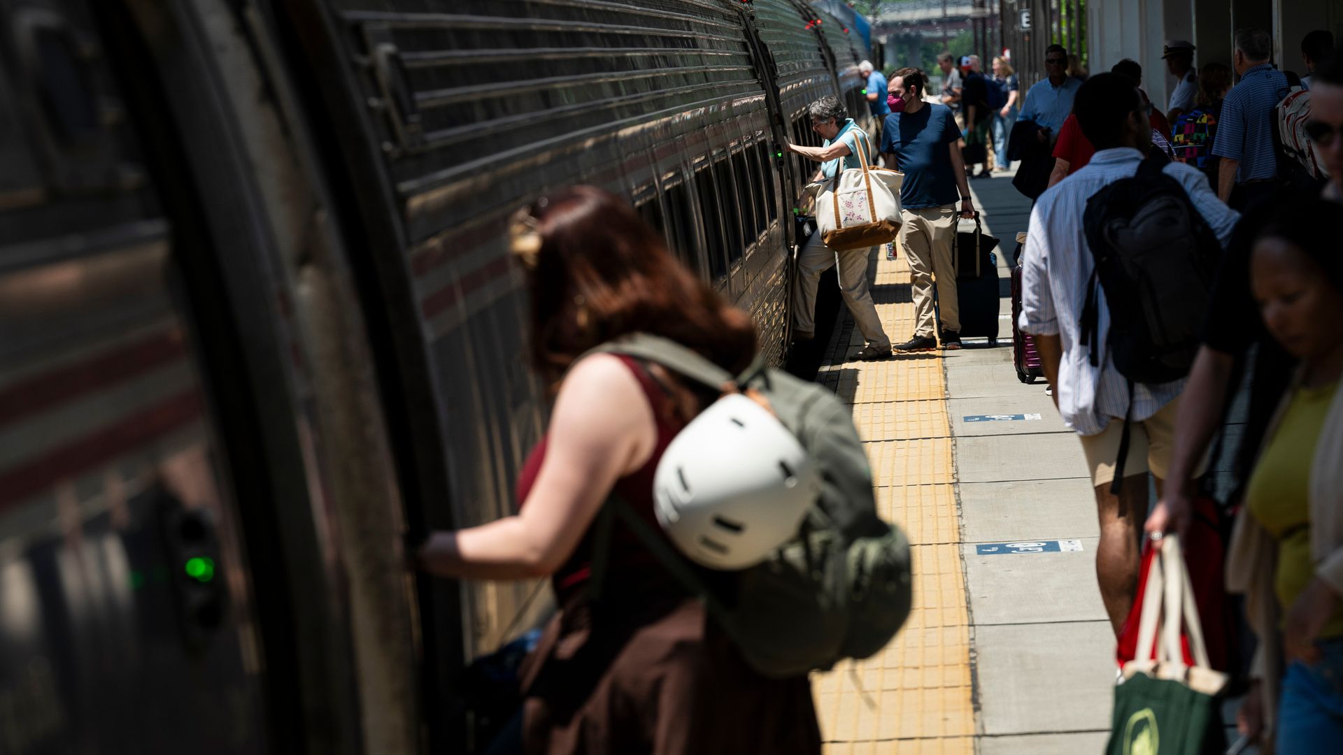 Passengers board an Amtrak train at a station. 