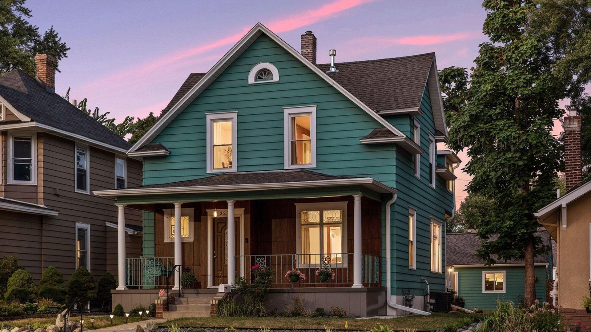 green exterior of home against sunset sky