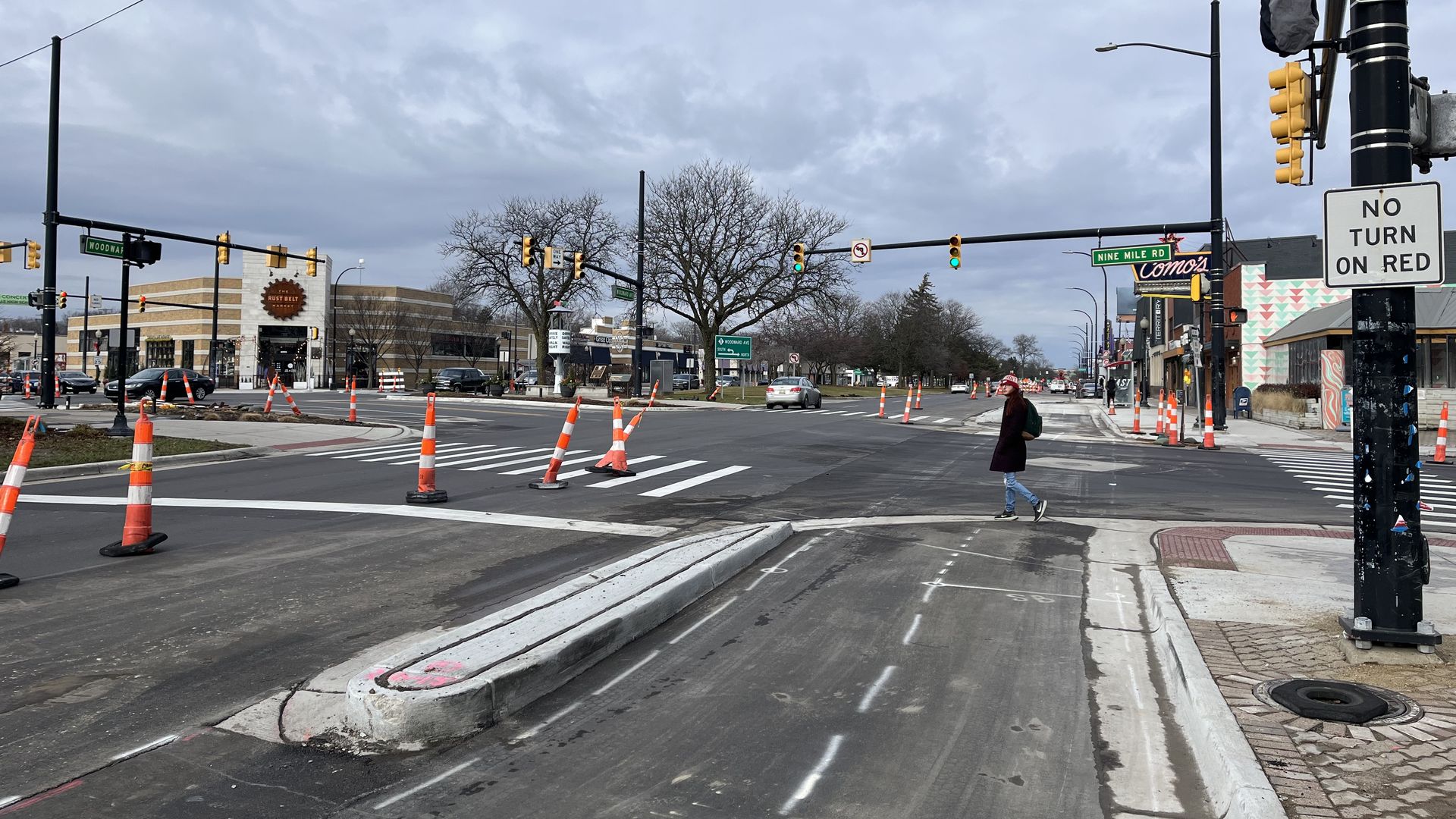 A pedestrian crosses Woodward at 9 Mile, an intersection being improved as part of new road construction.