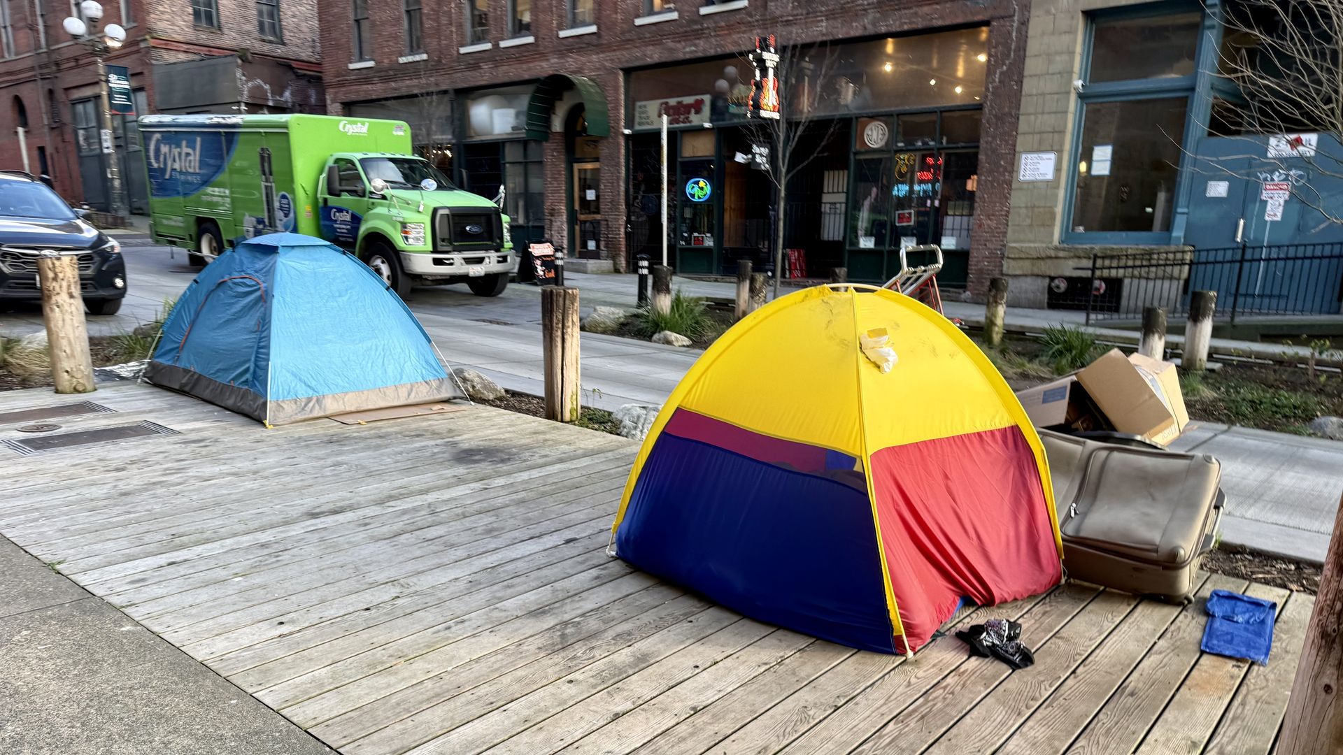 A photo of two brightly-colored tents on a public walkway in Seattle. 