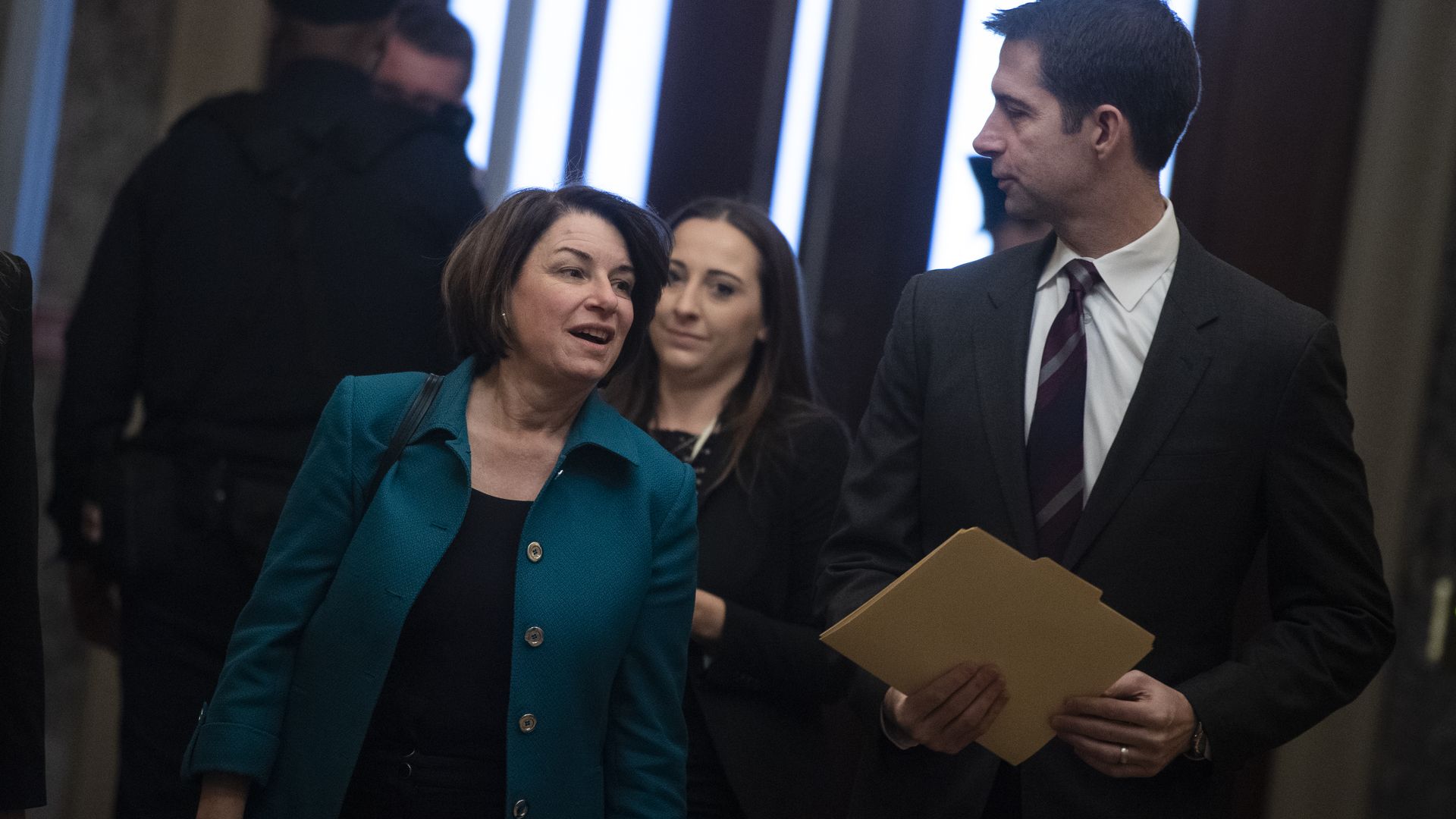 Senators Amy Klobuchar and Tom Cotton walk together.