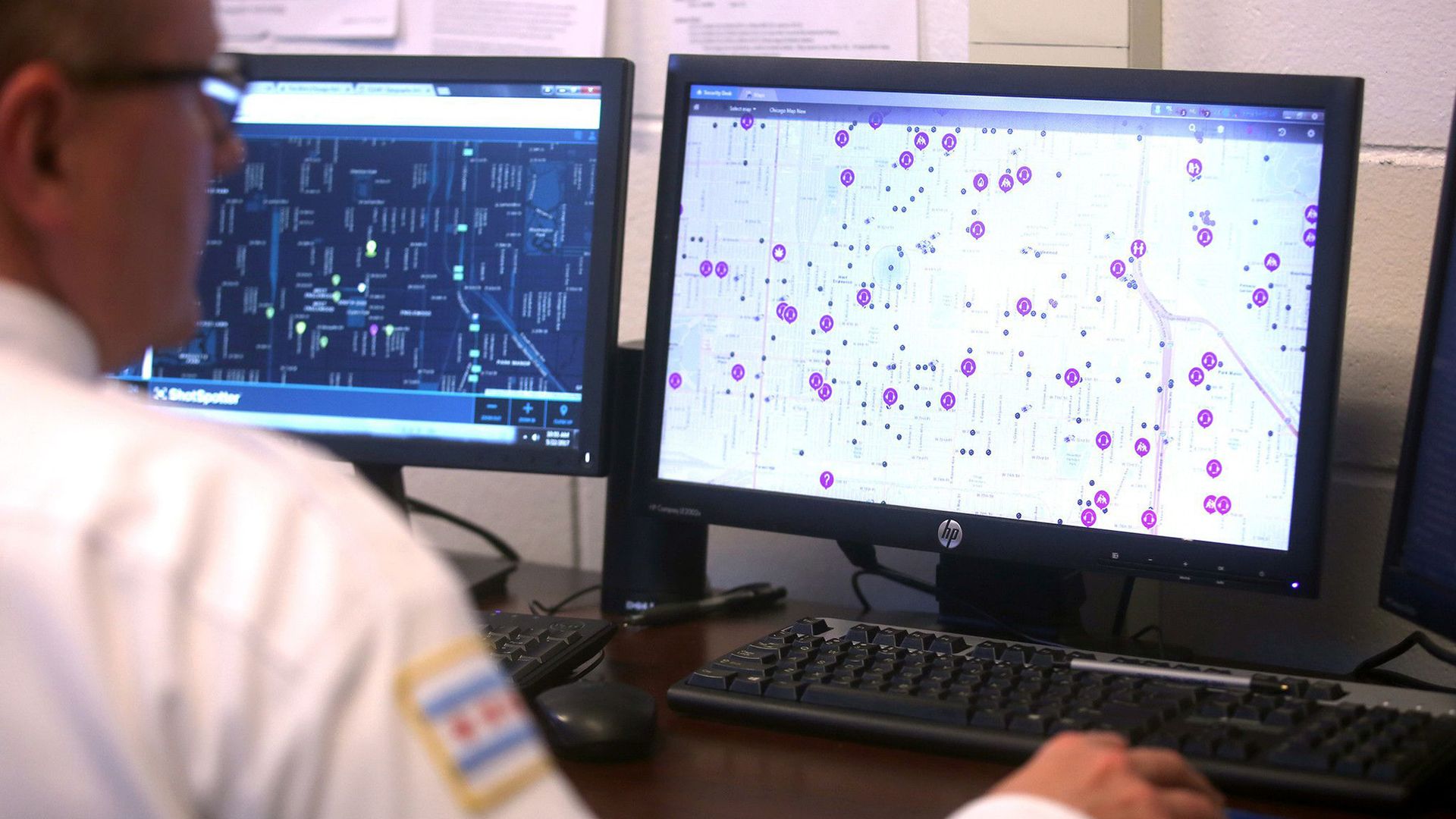 Photo of a police officer staring at a map on a computer screen.