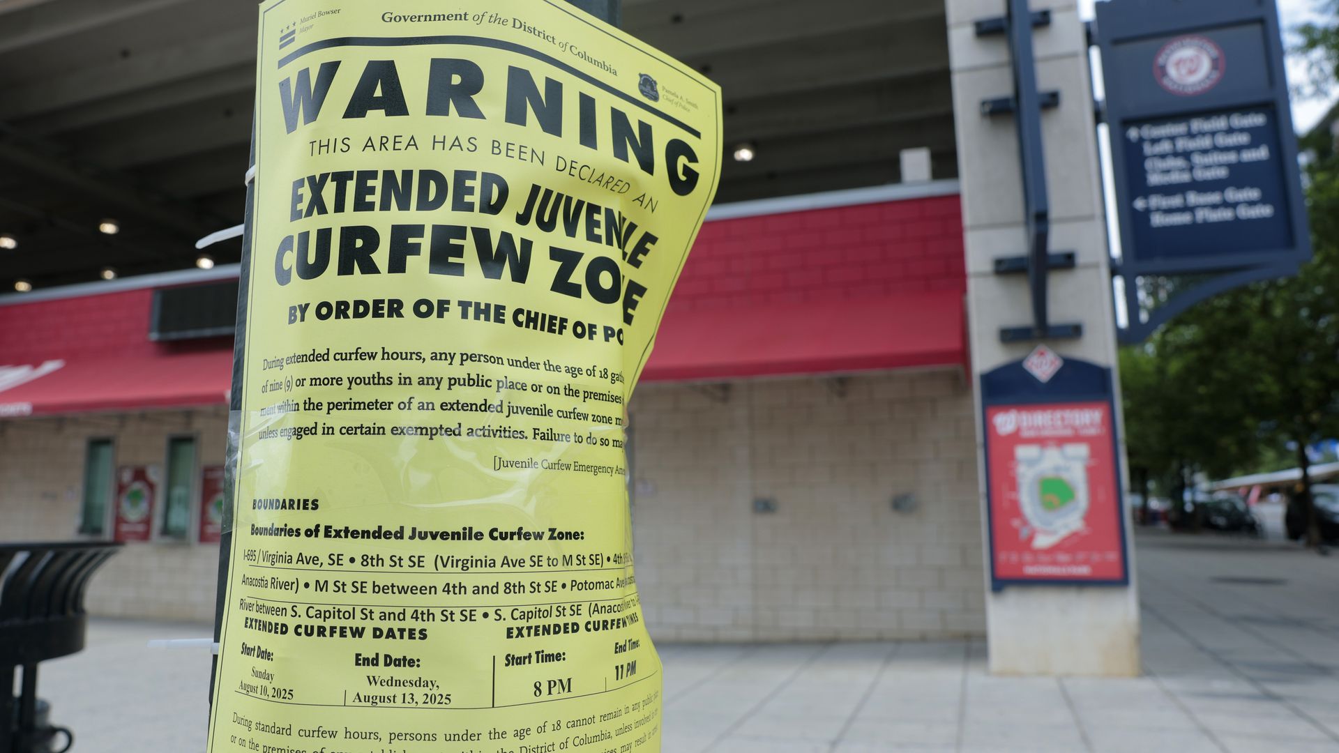 A street lamppost flyer giving notice of a juvenile curfew zone outside Nats Park