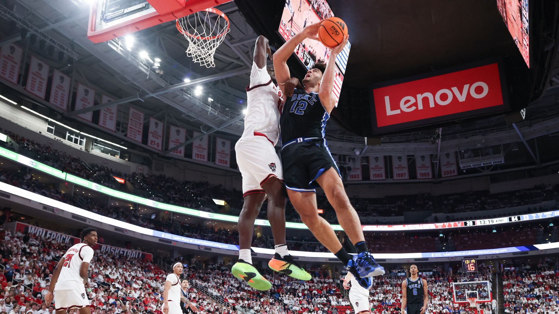 RALEIGH, NC - MARCH 02: Cameron Boozer #12 of the Duke Blue Devils gets fouled by Scottie Ebube #12 of the NC State Wolfpack on the way to the basket during the college basketball game between the NC State Wolfpack and the Duke Blue Devils on March 2, 2026 at the Lenovo Center in Raleigh, N.C. (Phot