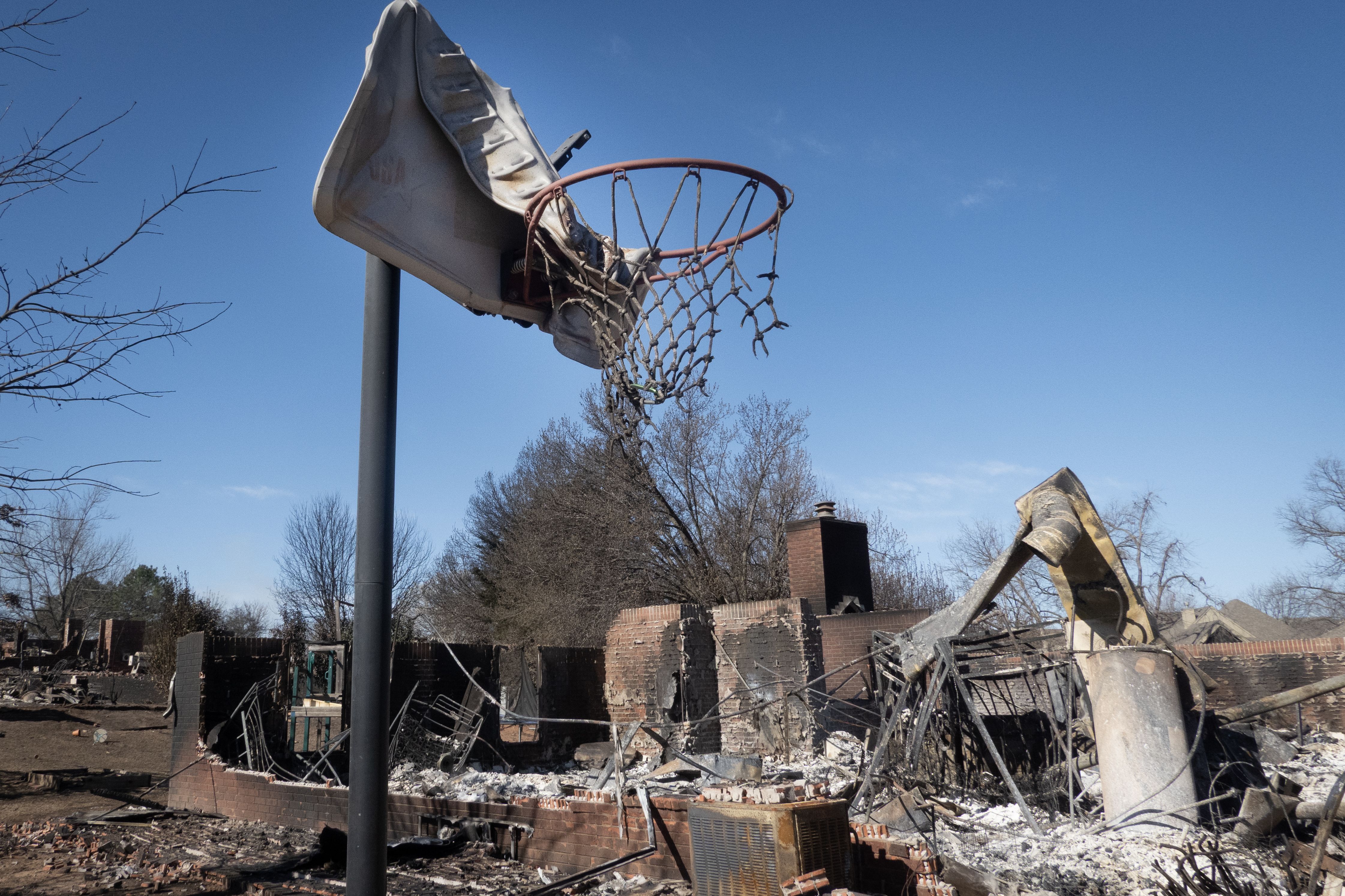  A basketball hoop sits in front of a home that was destroyed during Friday's wildfires on March 16, 2025 in Stillwater, Oklahoma. 