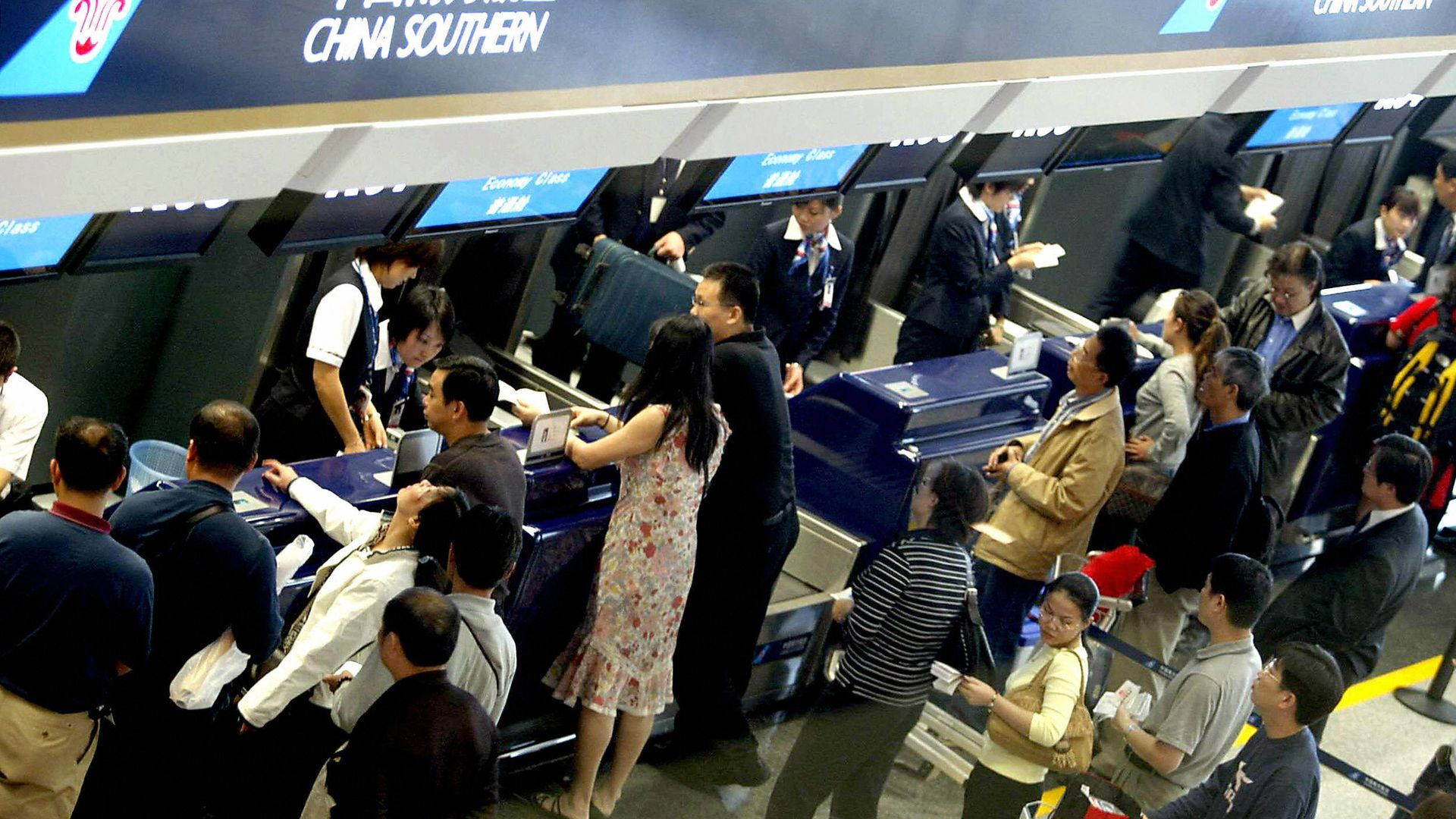 hinese airline passengers queue up at the newly reopened terminal of Beijing's Capital International Airport, 20 September 2004.