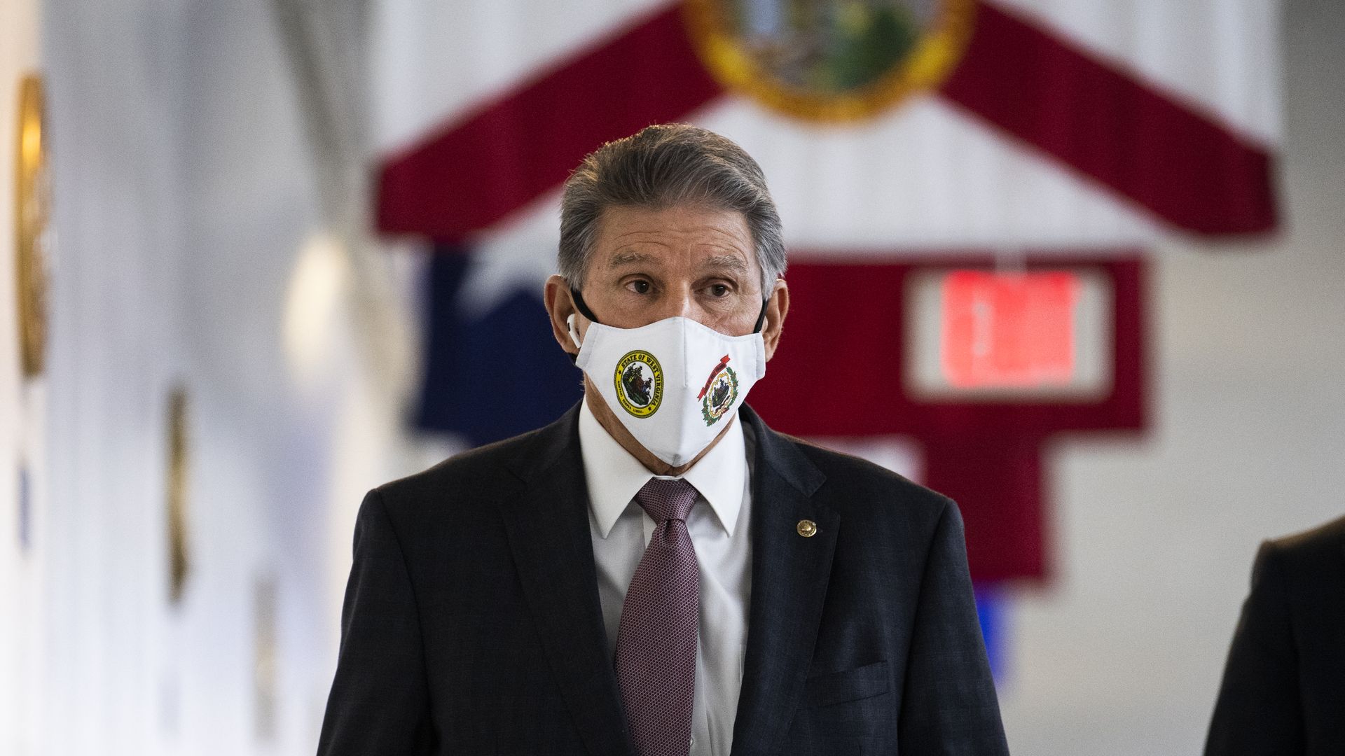 Sen. Joe Manchin is seen walking by a Florida flag as he enters the U.S. Capitol.