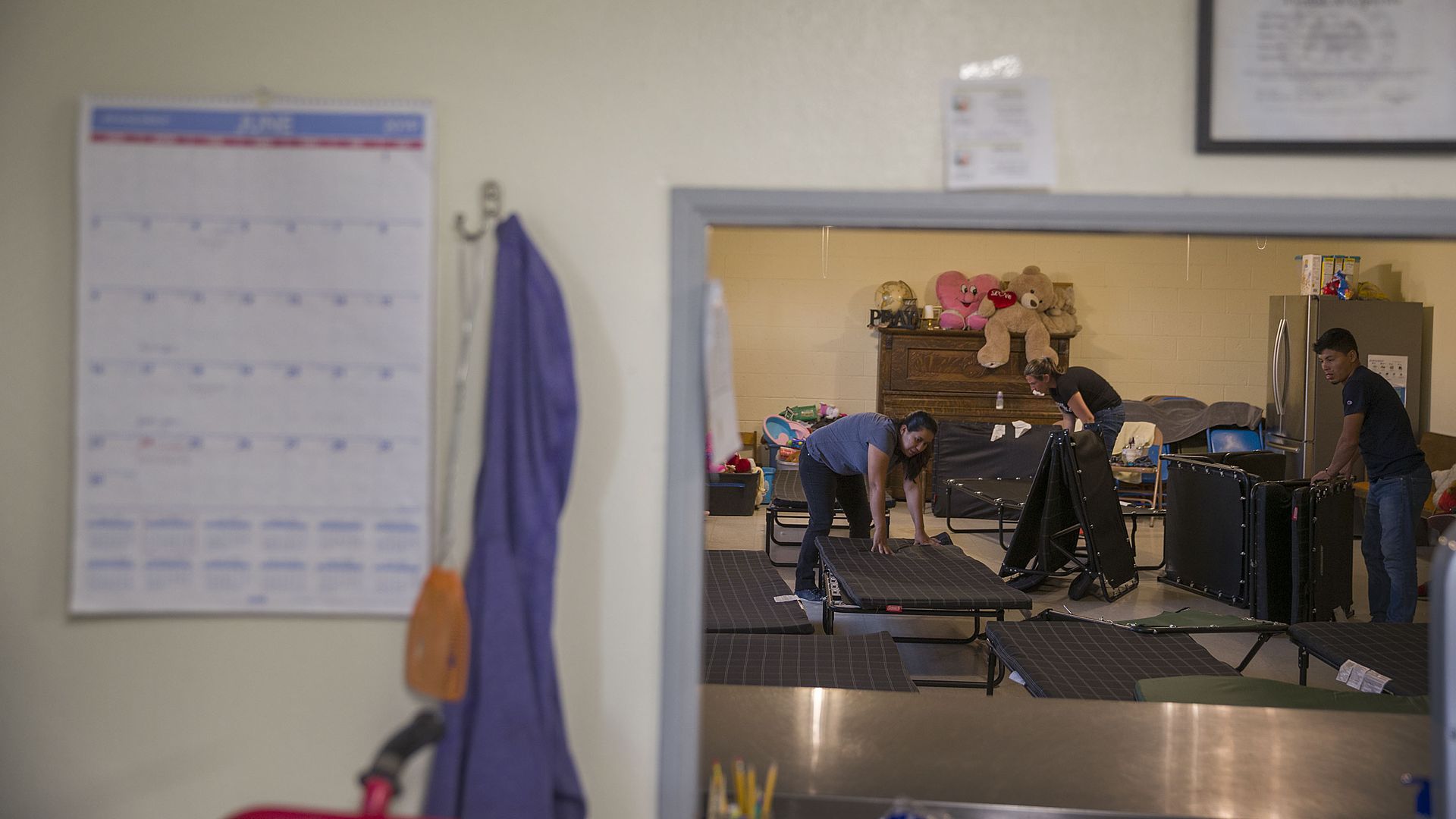 Migrants mostly from Honduras, Guatemala and Brazil prepare cots to sleep on