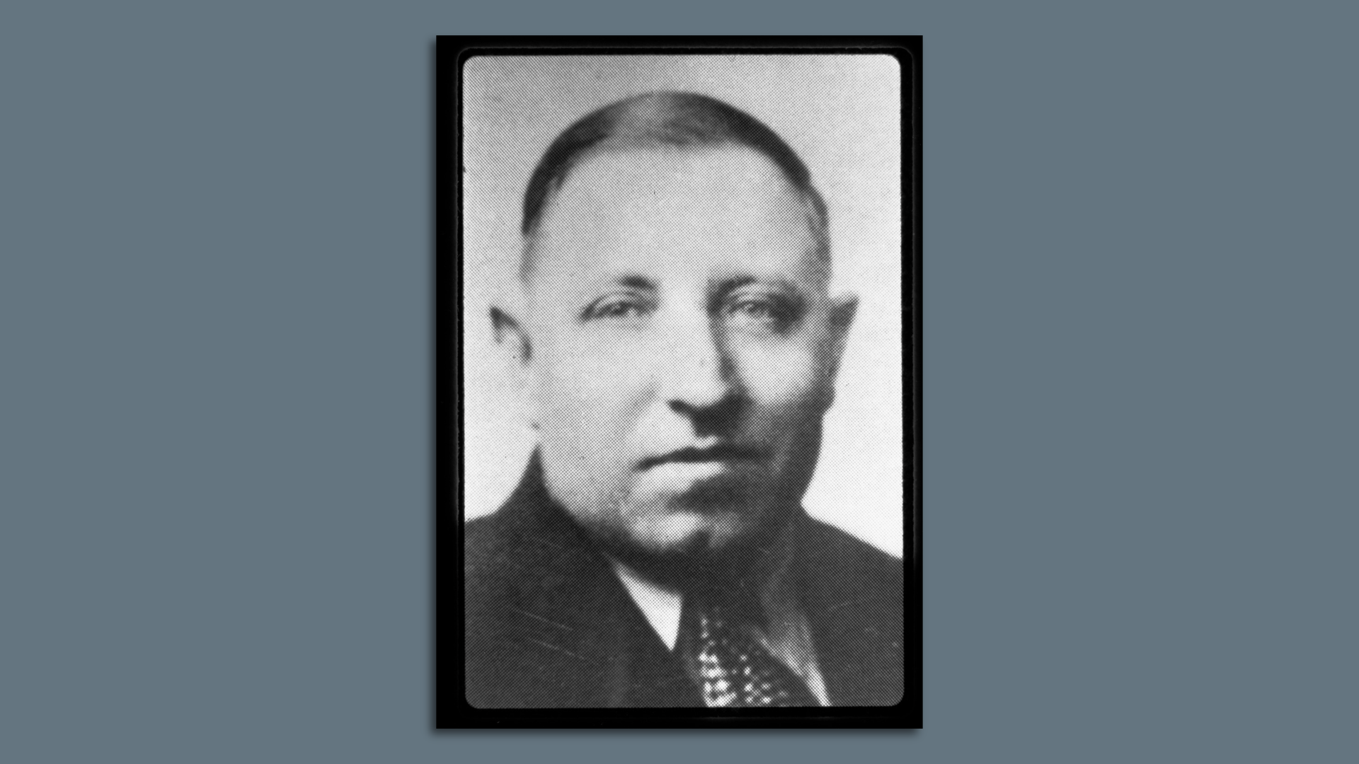 Black and white portrait of a man wearing a suit and tie.