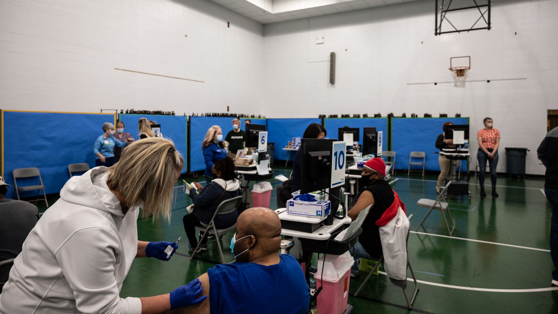 A man receives his COVID-19 vaccine from a nurse in the gymnasium at Whitney M. Young Elementary School on April 2, 2021 in Louisville, Kentucky
