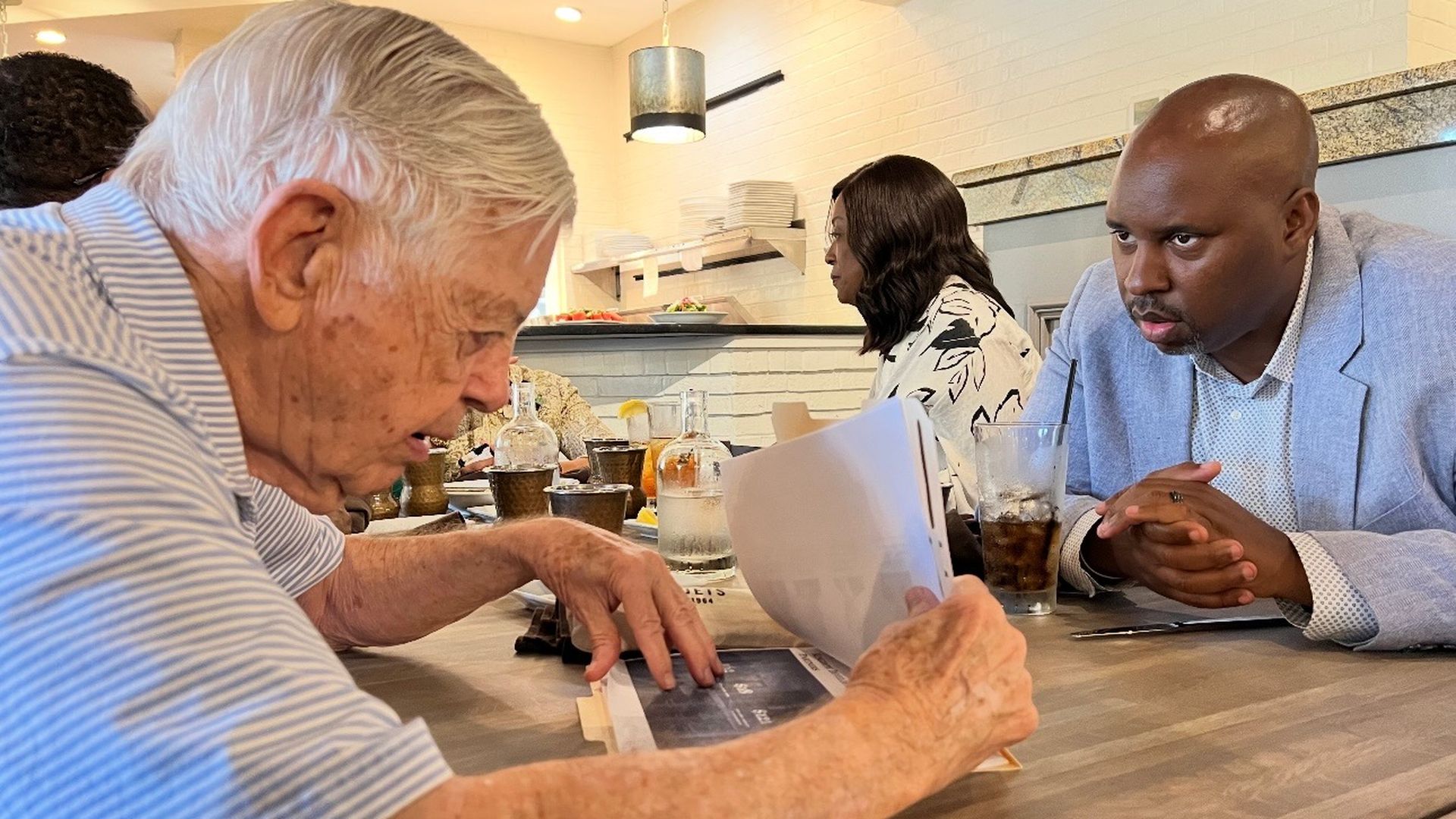 McColl and Scruggs at a table, looking at papers