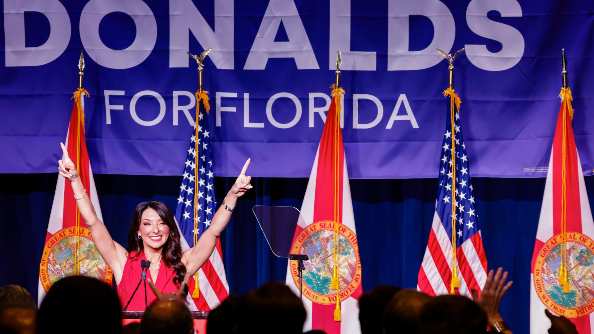Erika Donalds at a a primary election night event with two #1 fingers in the air.