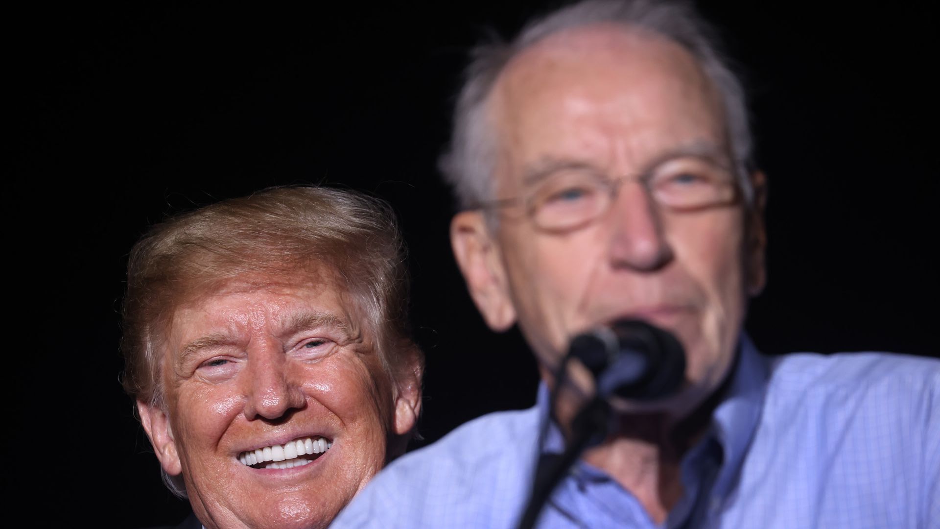 Former President Donald Trump smiles at Sen. Chuck Grassley during a Des Moines rally Oct. 09, 2021.