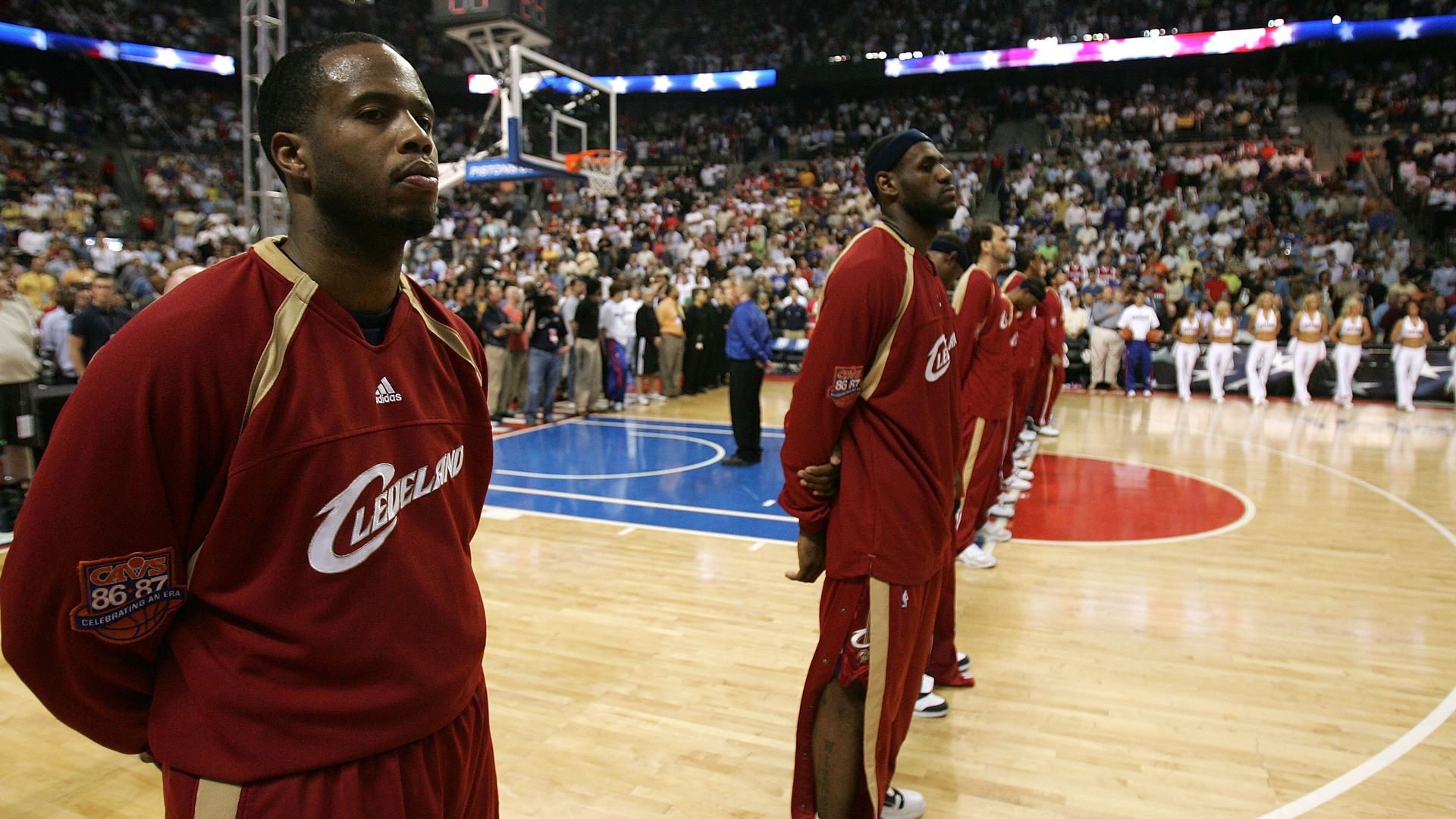 Cavs Guard Damon Jones in red warmups standing in line on basketball court