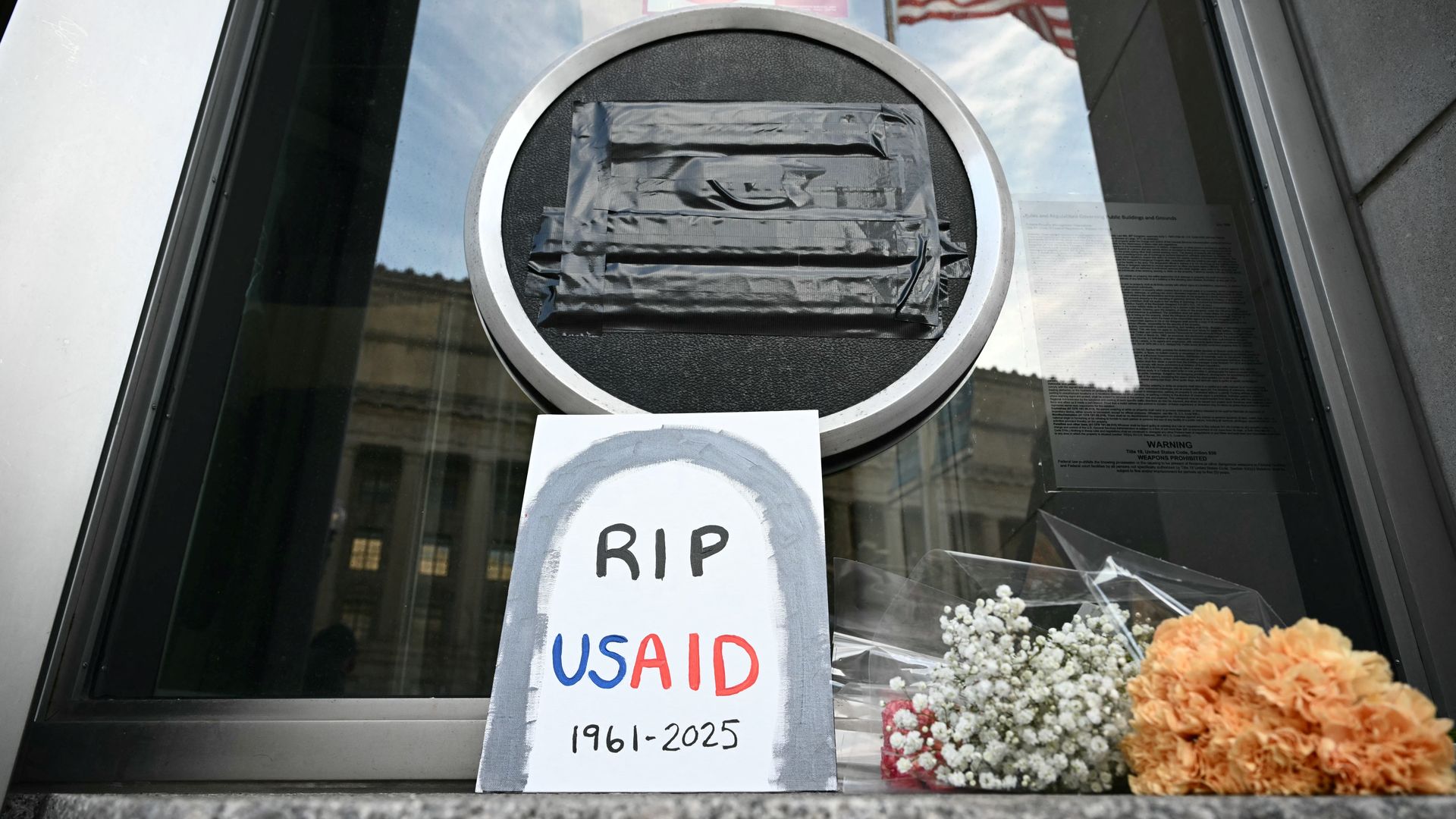  Tributes are placed beneath the covered seal of the US Agency for International Development (USAID) at their headquarters in Washington, DC, on February 7, 2025.