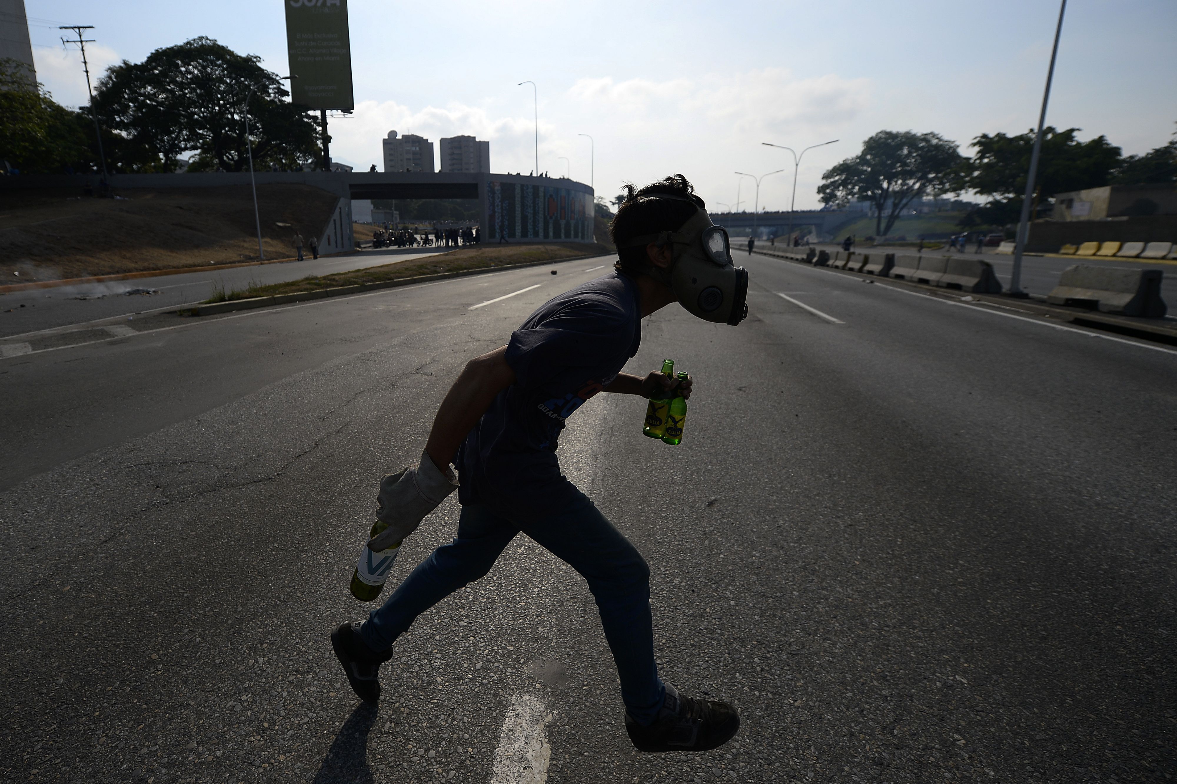 An opposition demonstrator runs during clashes with soldiers loyal to Venezuelan President Nicolas Maduro Tuesday.