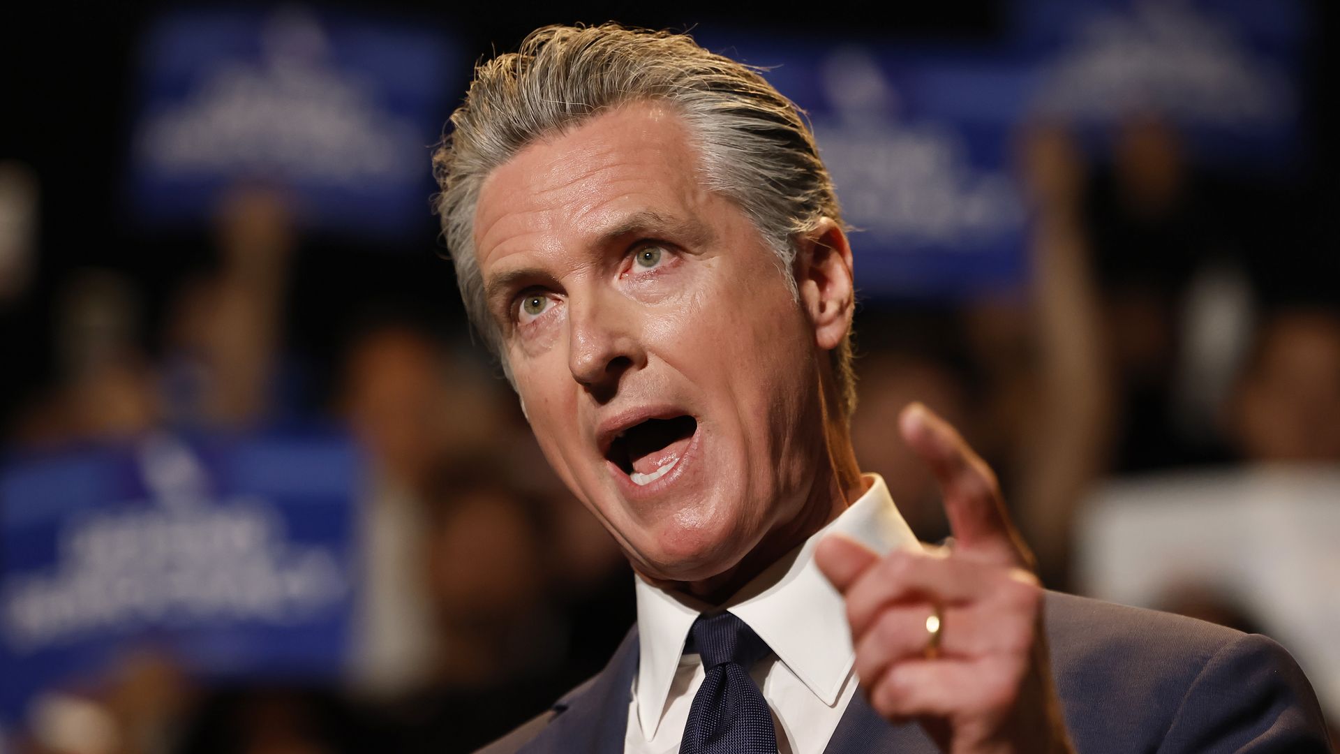 Close up photo of Gavin Newsom speaking, pointing a figure to crowd