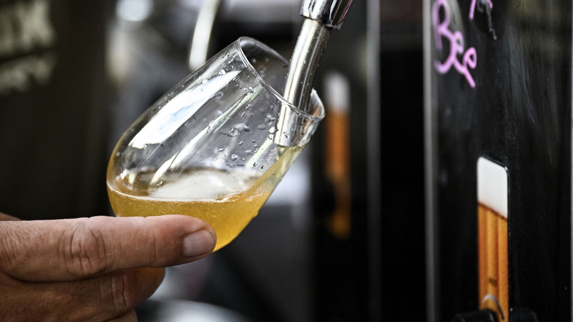 An employee pours the craft beer into a glass at the Croix de Chavaux brewery in Montreuil, near Paris, on June 20, 2025. The beer industry has been struggling since the post-Covid era. Direct sales saved the "Croix de Chavaux" brewery thanks to the creation of "brewpubs".