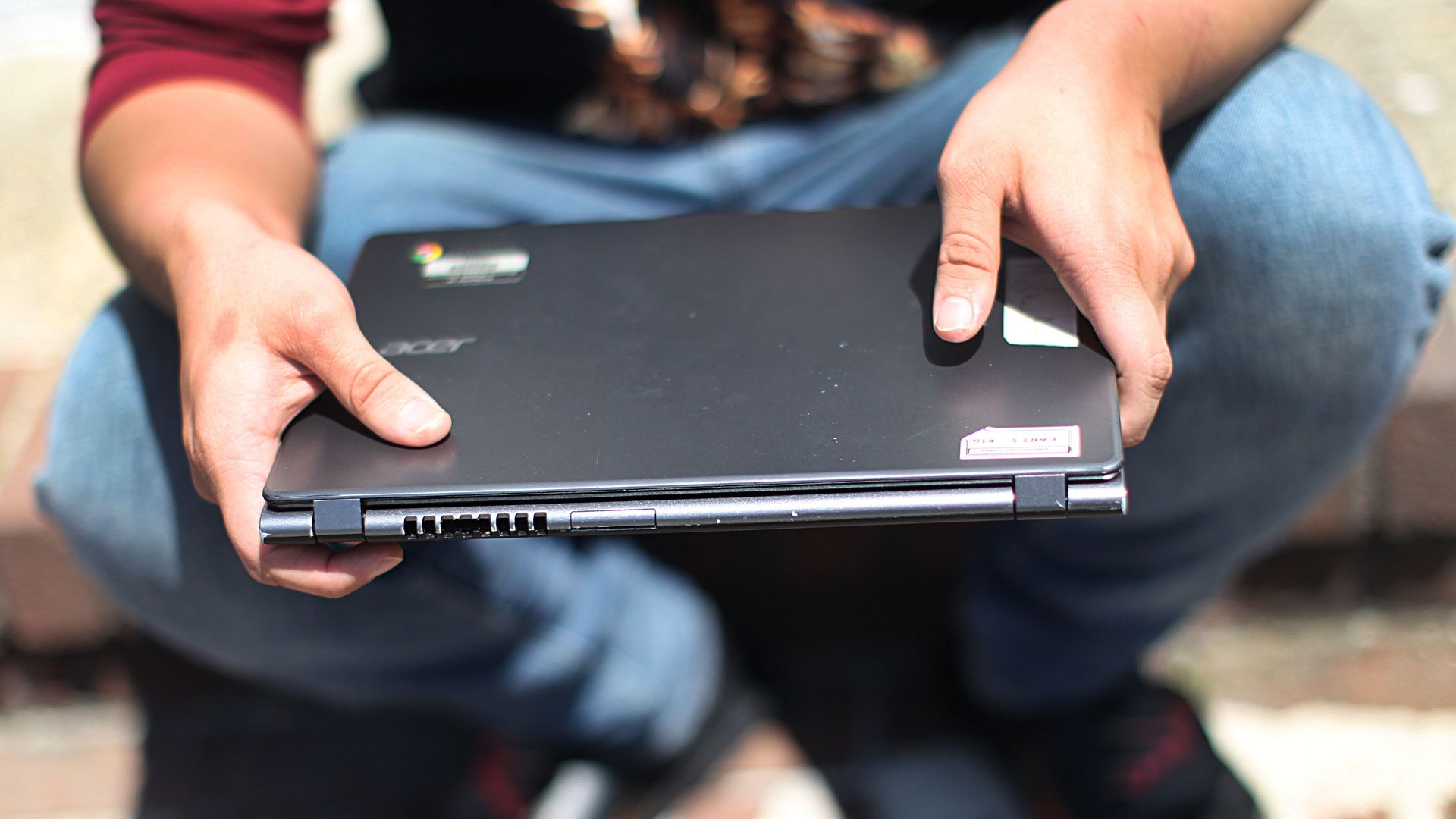 A student holds a laptop in his lap