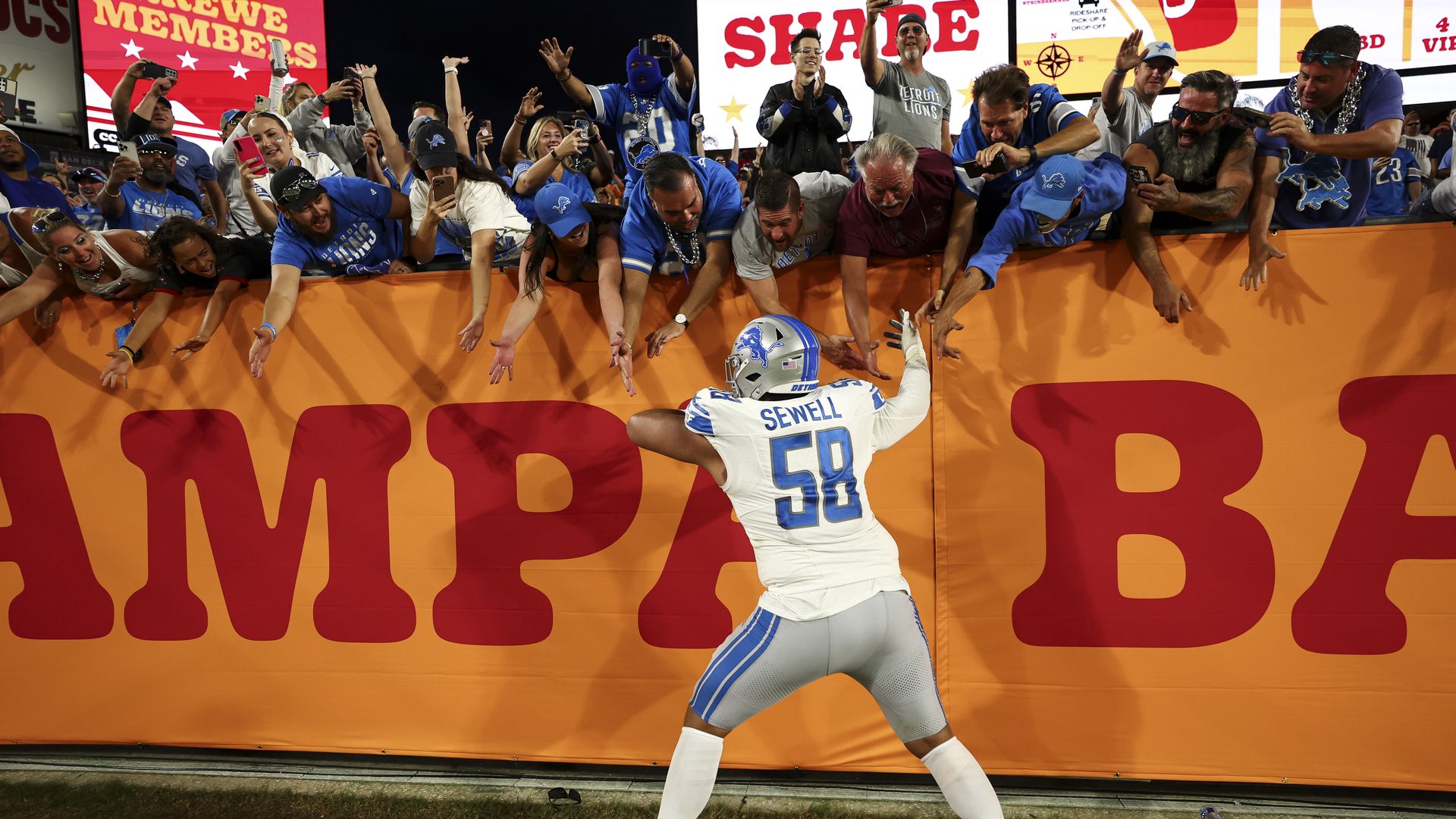 Offensive tackle Penei Sewell celebrates with Lions fans after beating the Tampa Bay Buccaneers at Raymond James Stadium on Sunday.