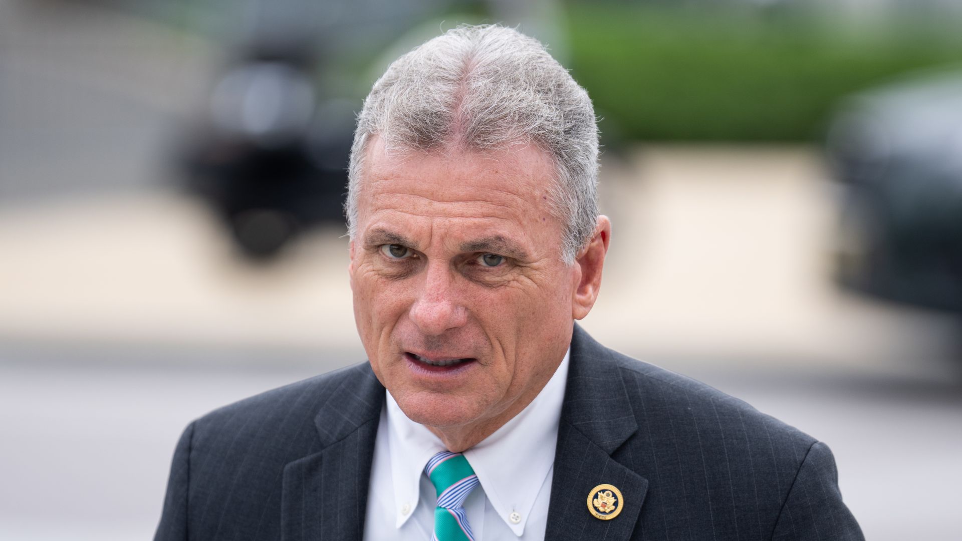 Rep. Buddy Carter wearing a gray suit and standing outside.