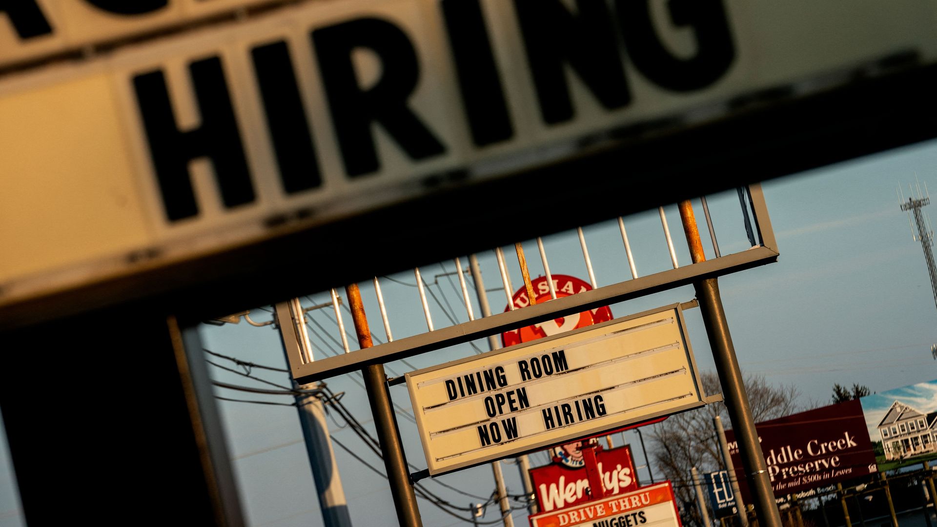 Now Hiring signs are displayed in front of restaurants in Rehoboth Beach, Delaware, on March 19, 2022