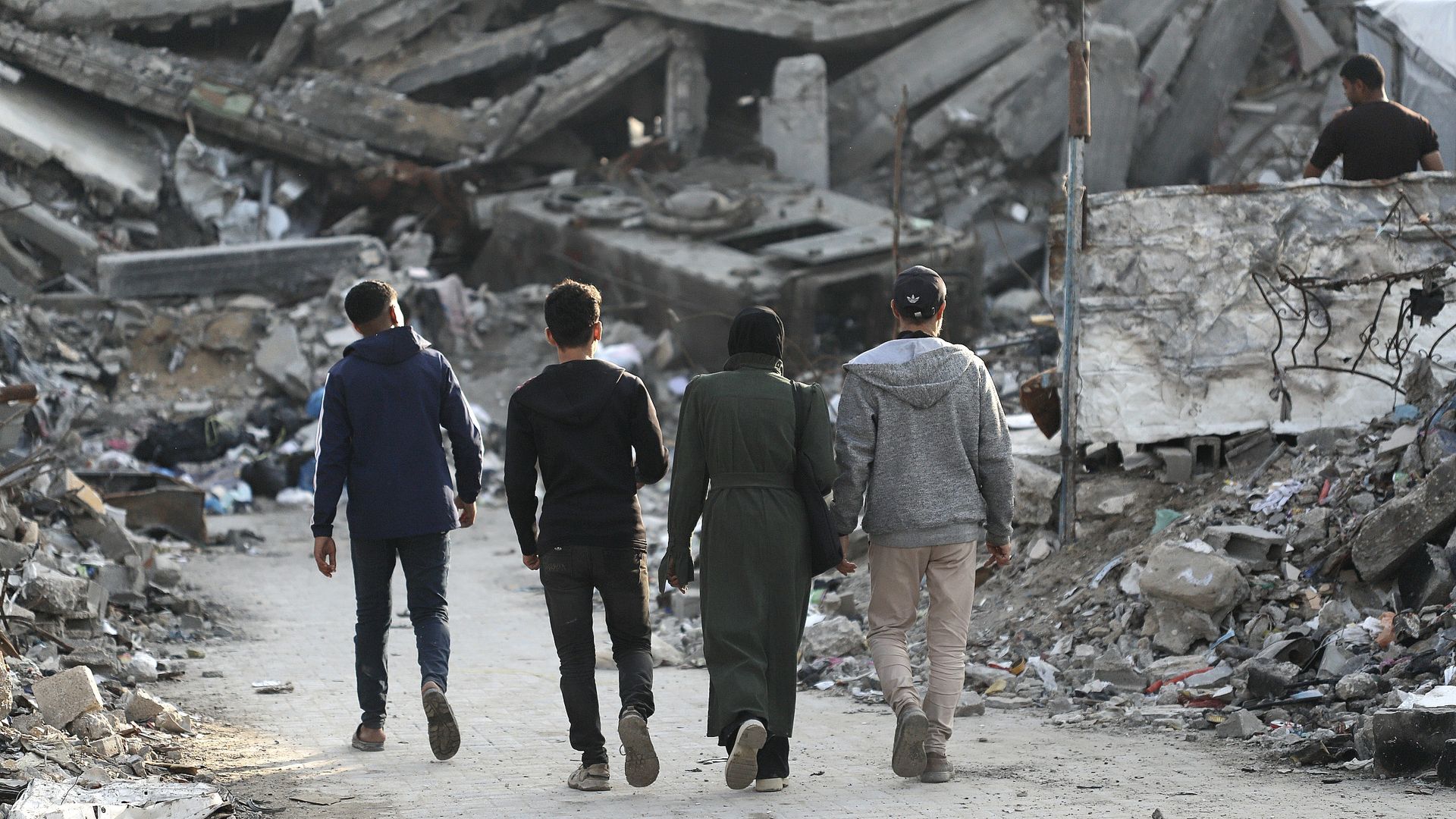 People walk along a path surrounded by destroyed buildings at the Jabalia refugee camp.
