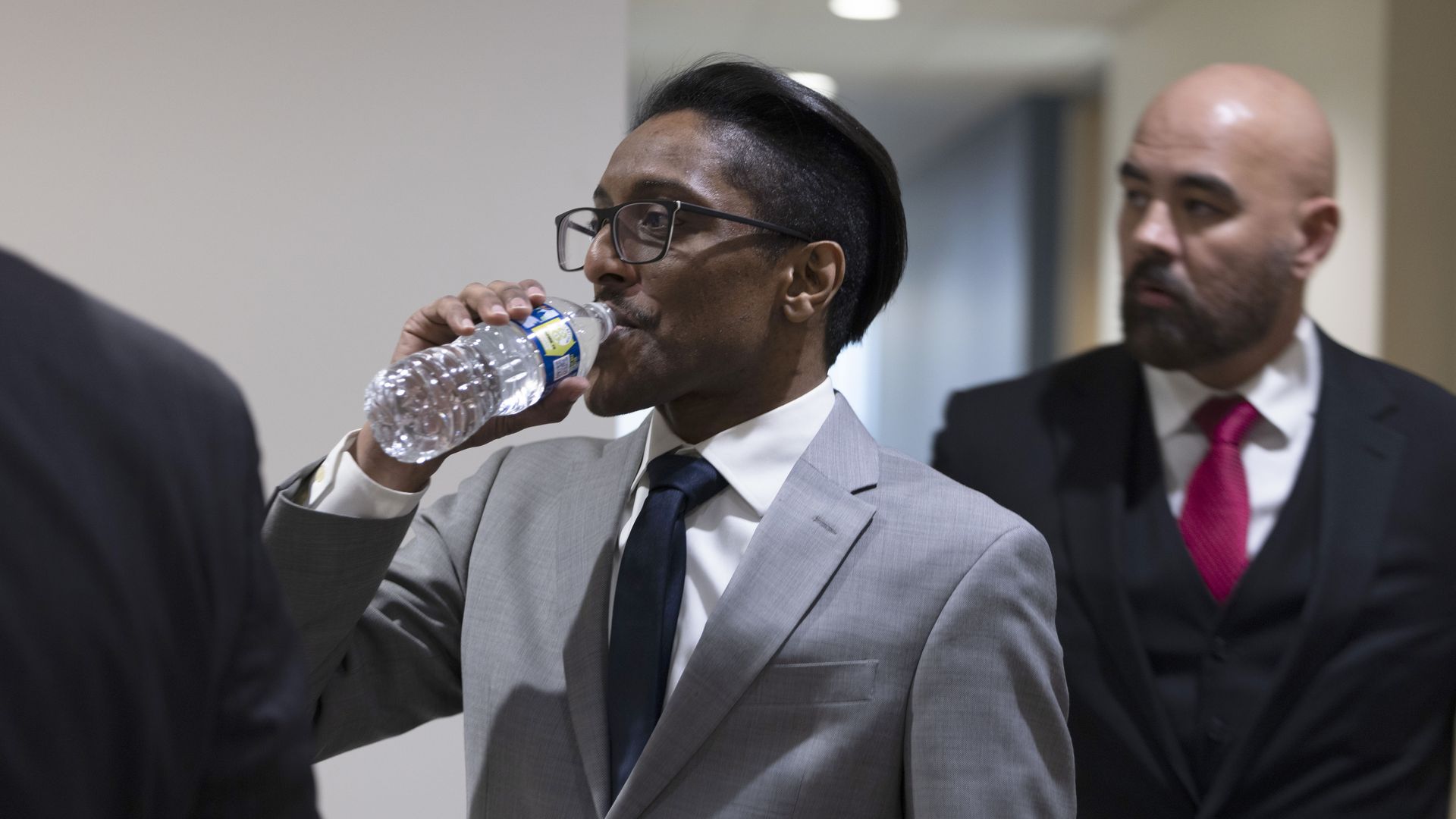 Photo of Ali Alexander drinking water from a plastic bottle