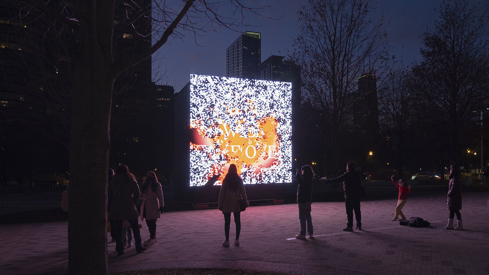 A large OCD screen with static on it, people standing in front of it.