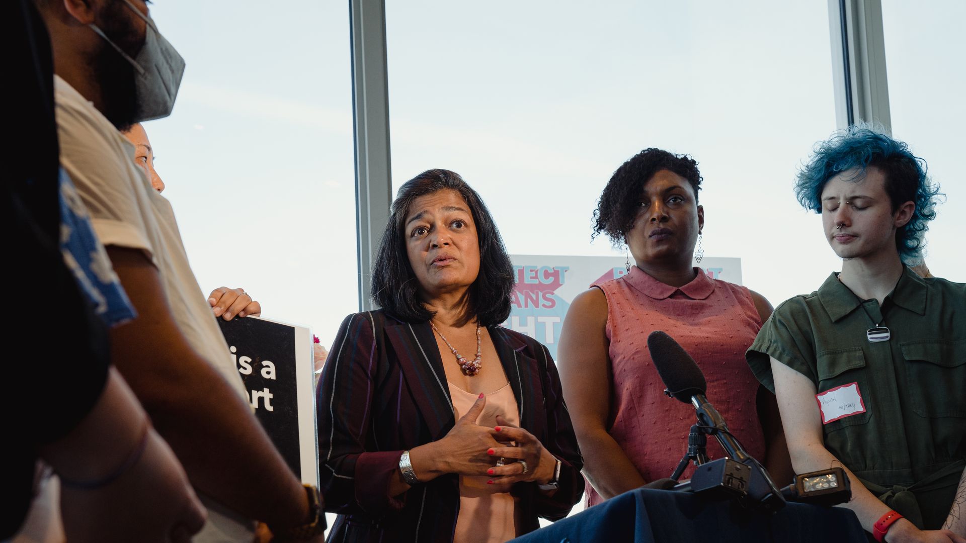 Rep. Pramila Jayapal, wearing a purple striped jacket and tan shirt, speaks at an event.