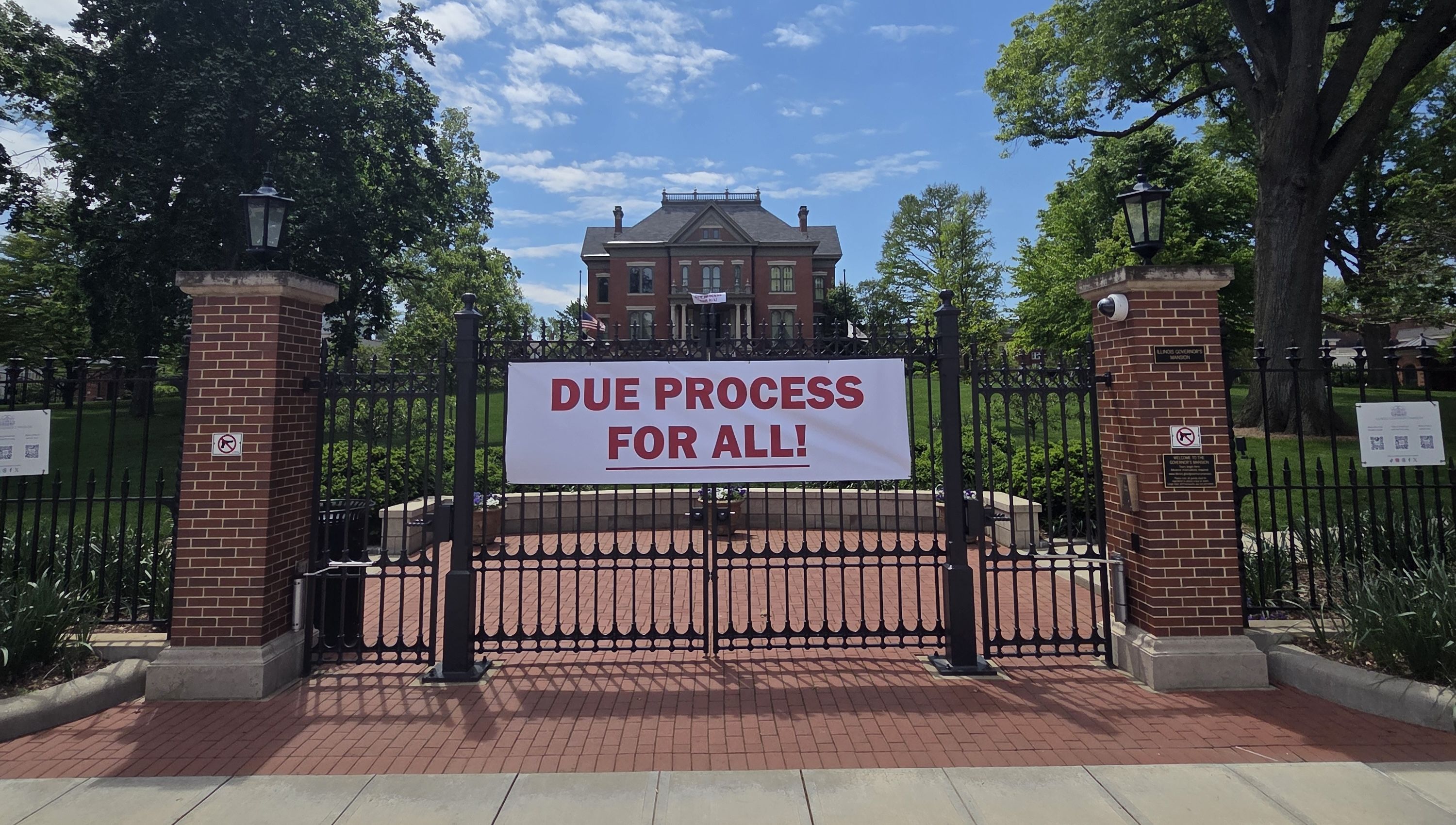governor's mansion with banner reading "Due Process for All!" 
