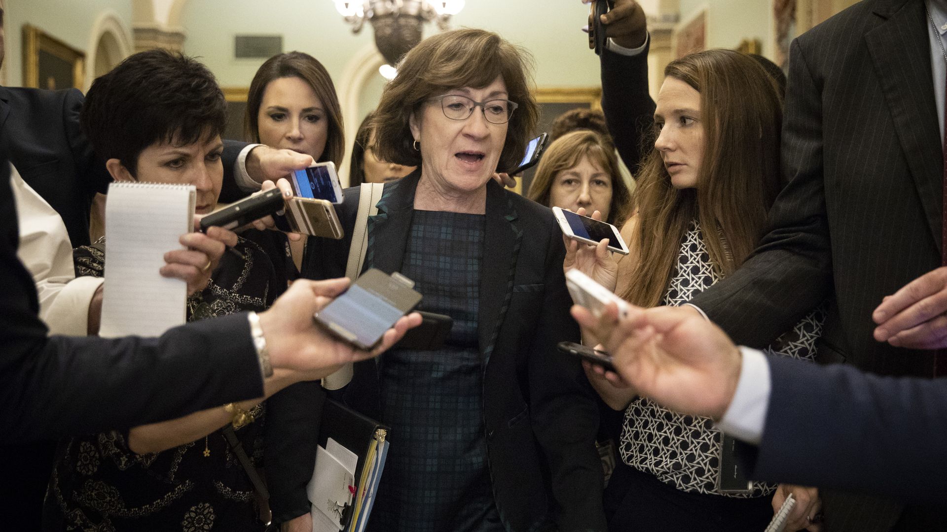 Susan Collins surrounded by reporters on Capitol Hill