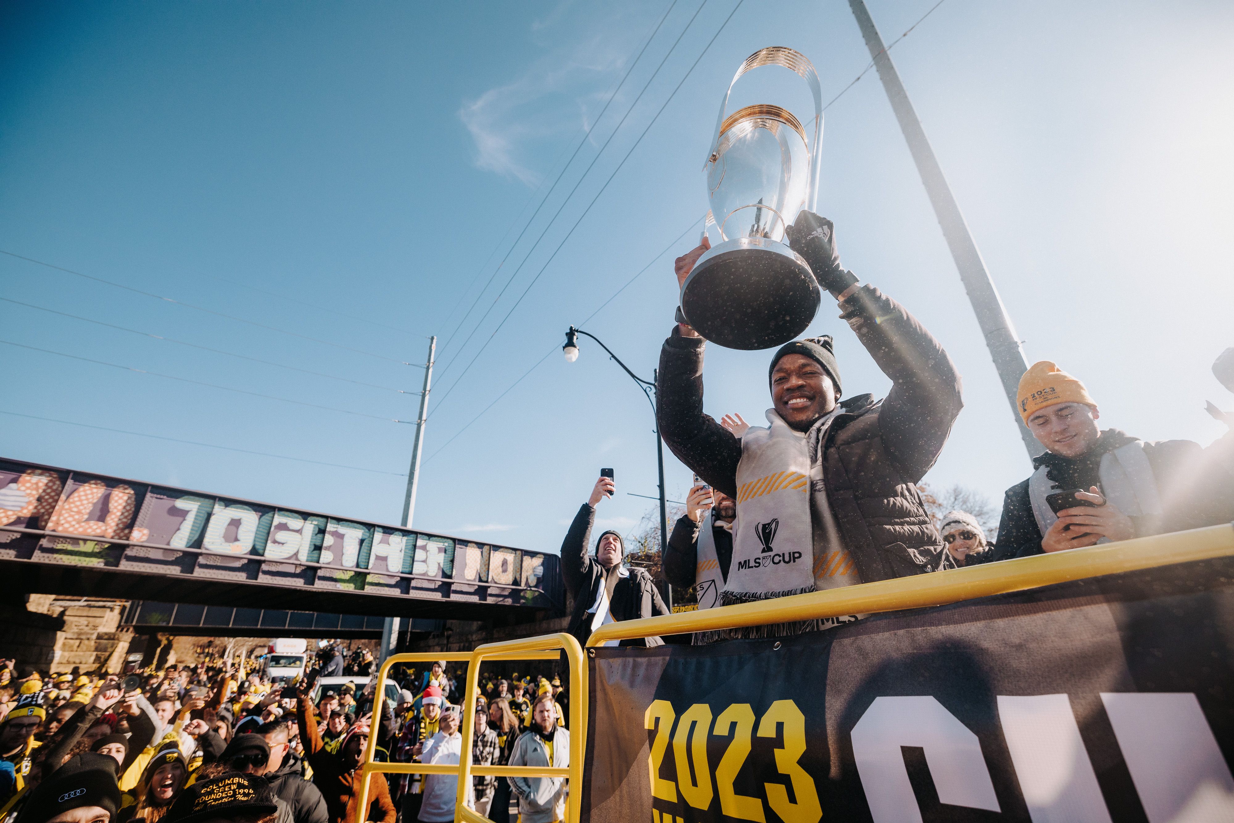 Darlington Nagbe holds up the Philip F. Anschutz Trophy on a parade float