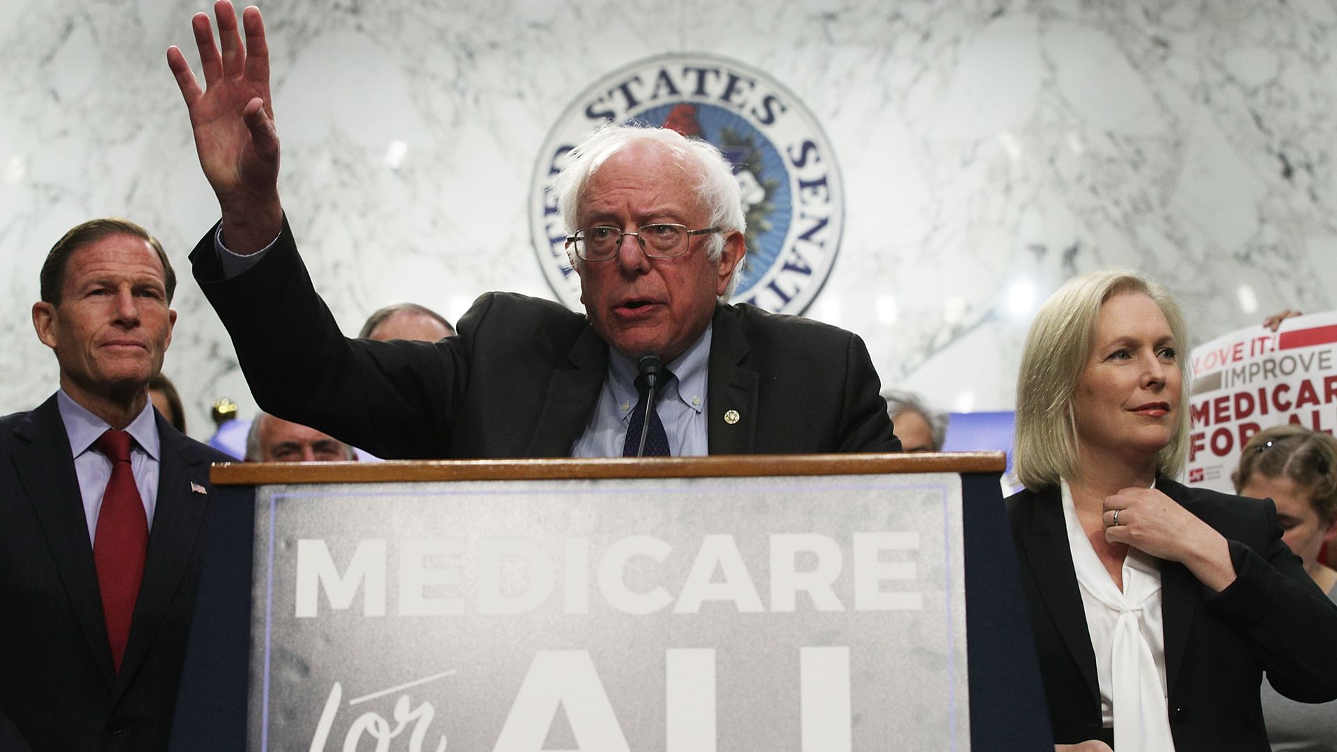Sen. Bernie Sanders speaks behind a lectern while introducing his "Medicare for All" bill