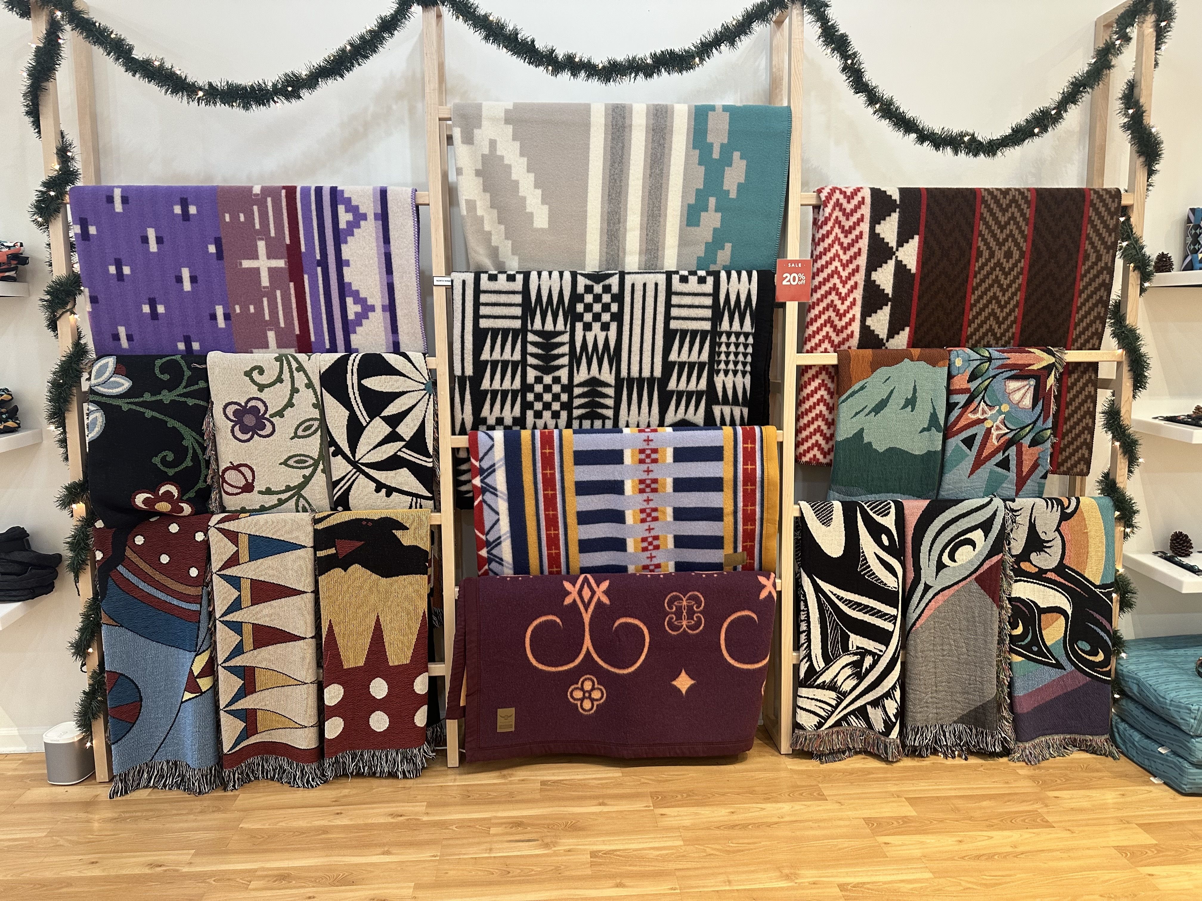 A display of wool blankets in different colors hanging in a store.