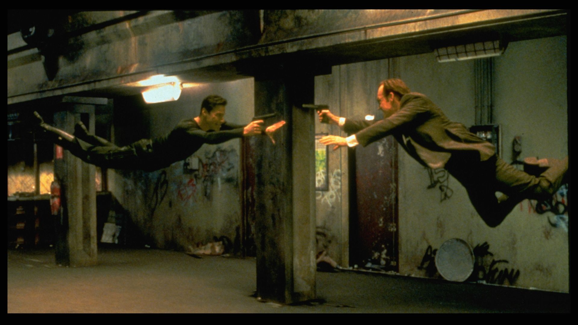 A still from The Matrix showing two people flying toward each other in battle.