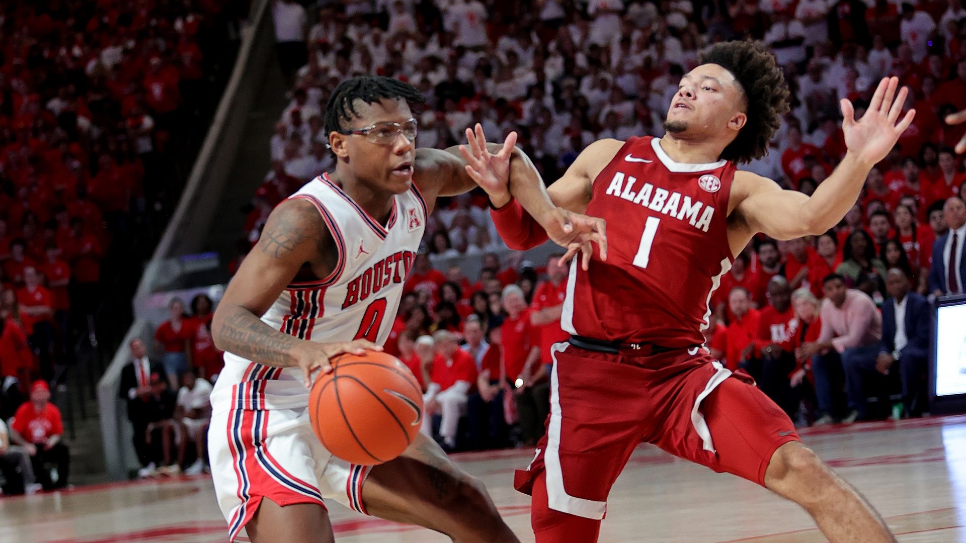 UH men's basketball player Marcus Sasser pushes off a defender while dribbling the ball 