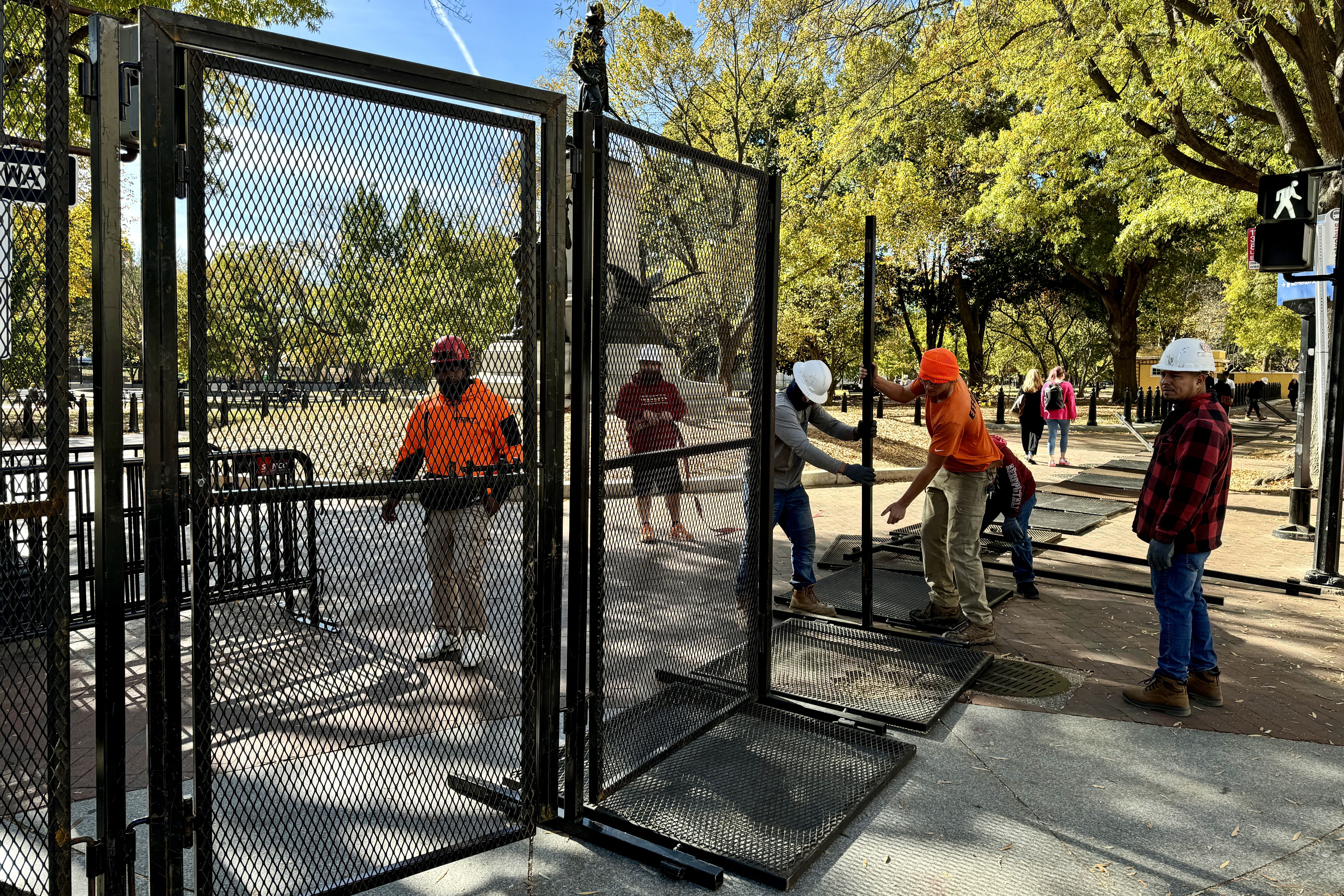 Security fencing is assembled around Lafayette Square as construction for the presidential inauguration parade takes place near the White House in Washington, DC, on November 3,