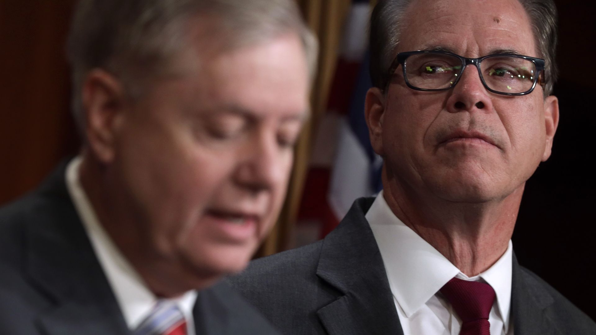 Sen. Mike Braun is seen looking on as Sen. Lindsey Graham speaks.