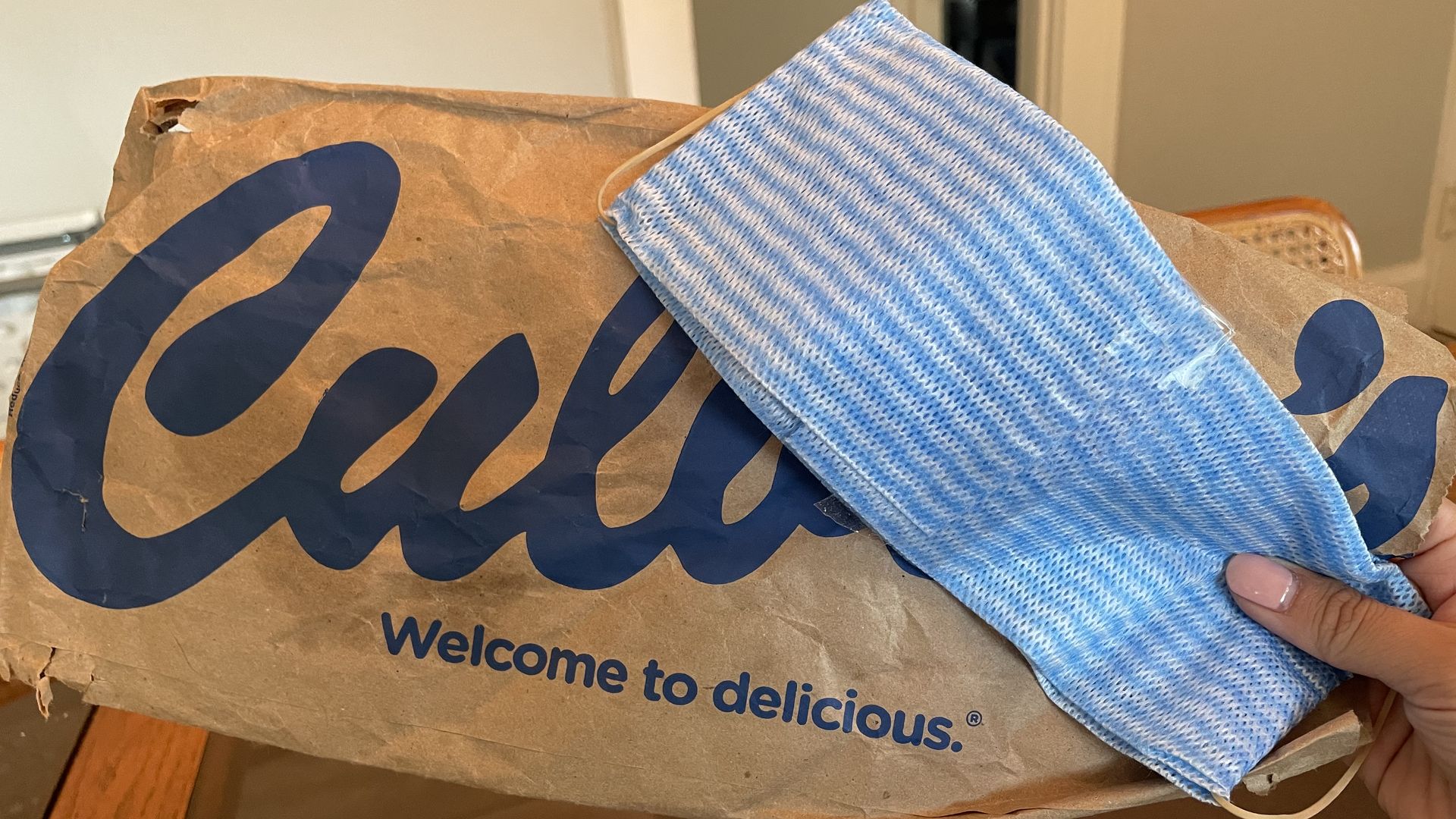 A DIY face mask in front of a Culver's fast food bag.