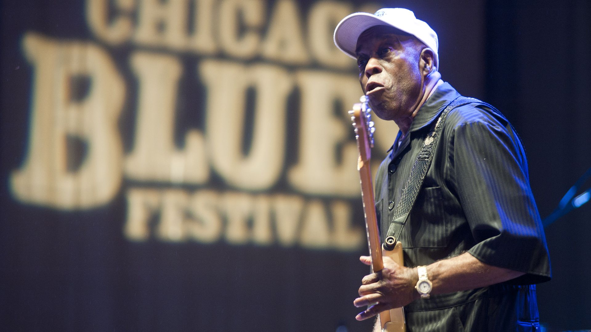 Photo of a man playing guitar on stage 