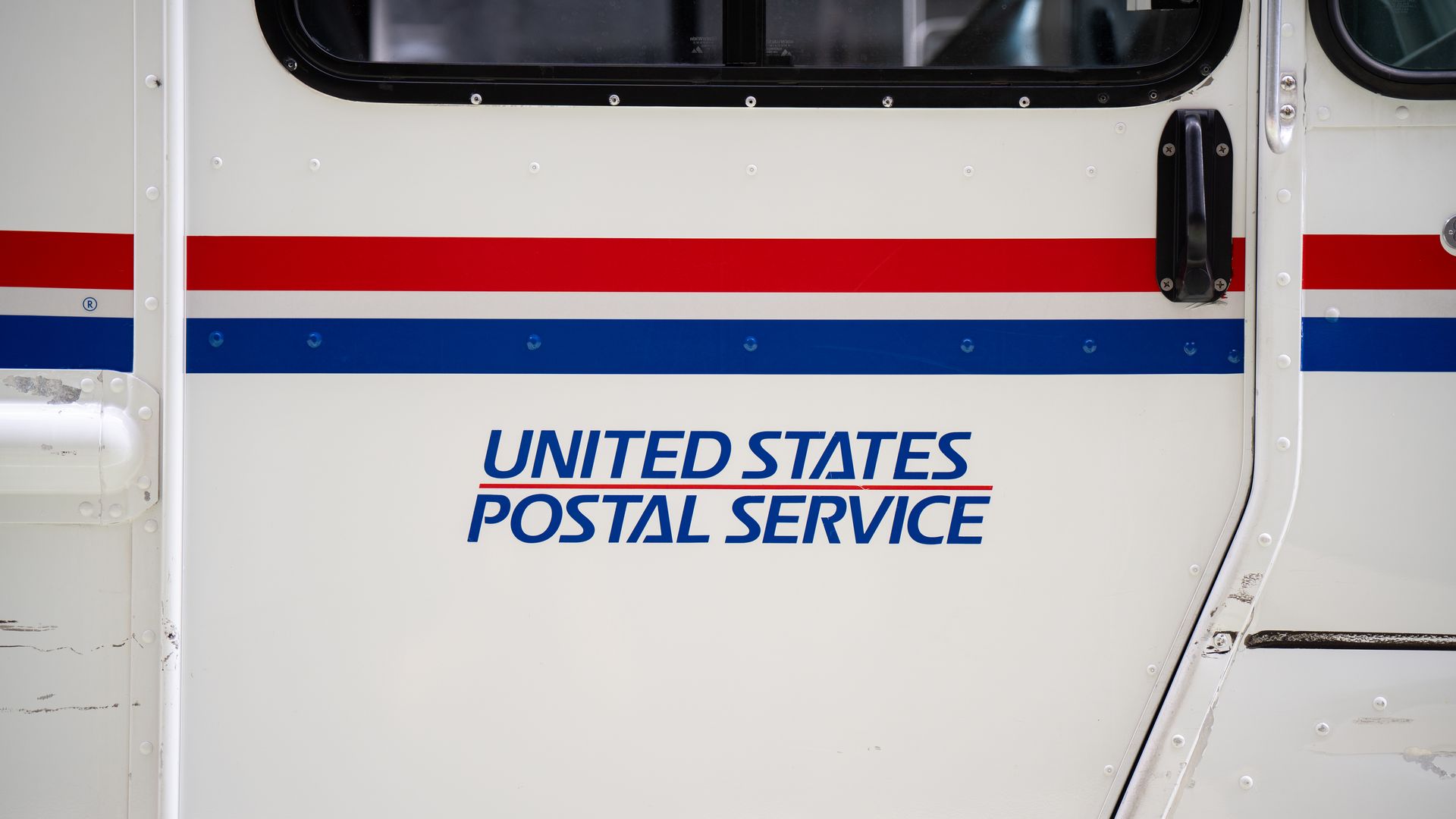 The side of a mail truck that says "United States Postal Service"