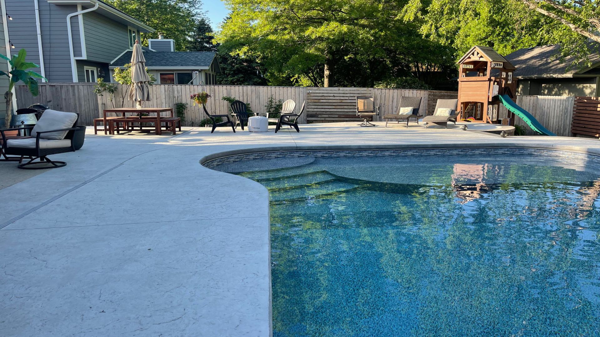 backyard pool with treehouse in background