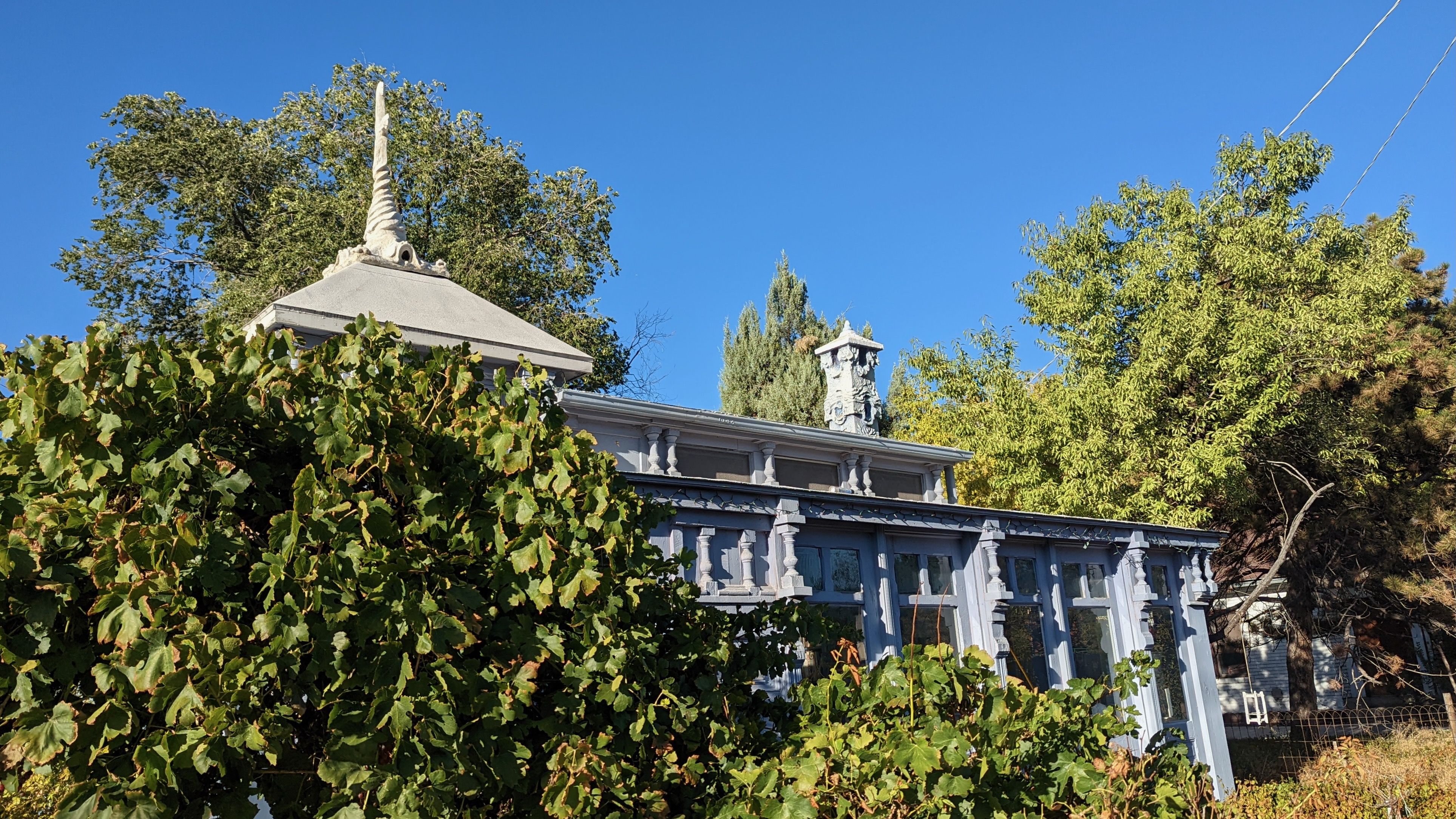 A house with a steeple and chimney decorated with stone work.