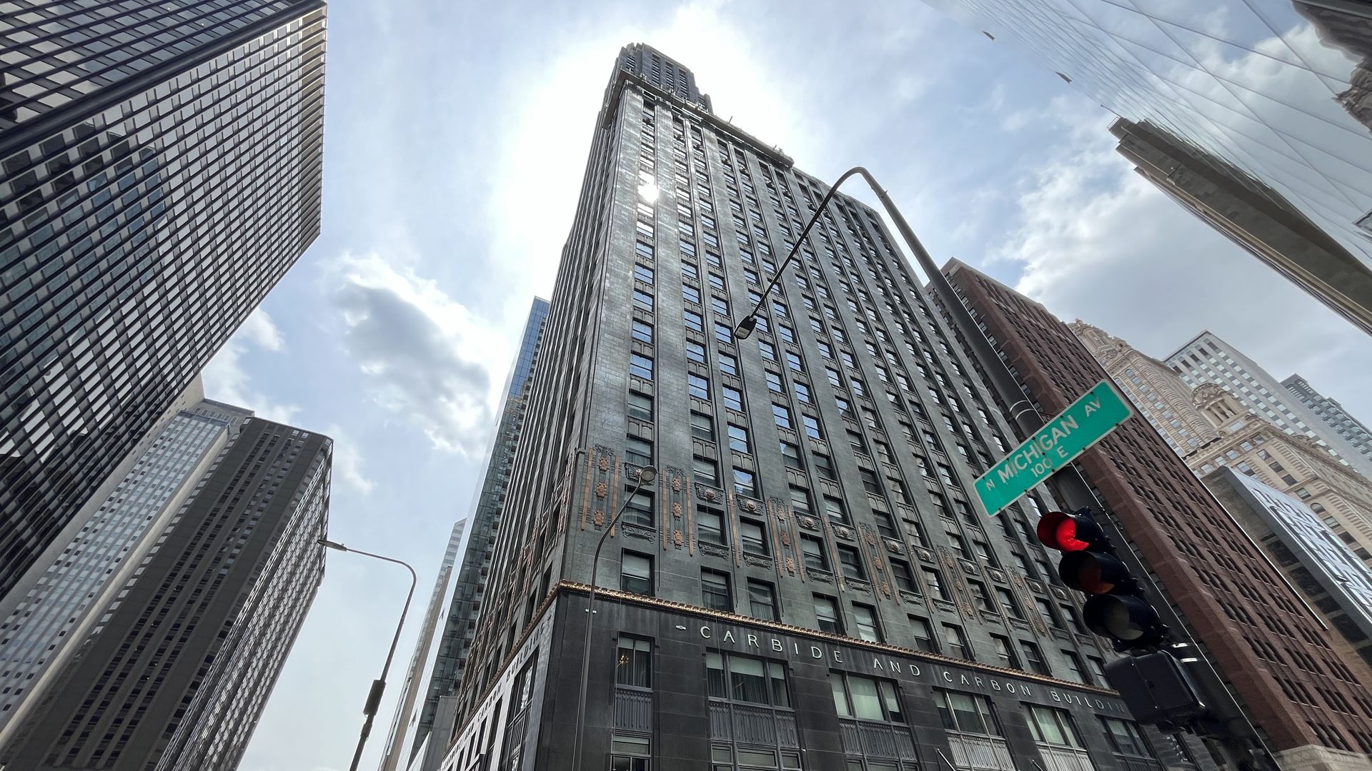 View from the street up a gray Art Deco building with a green Michigan Avenue street sign.