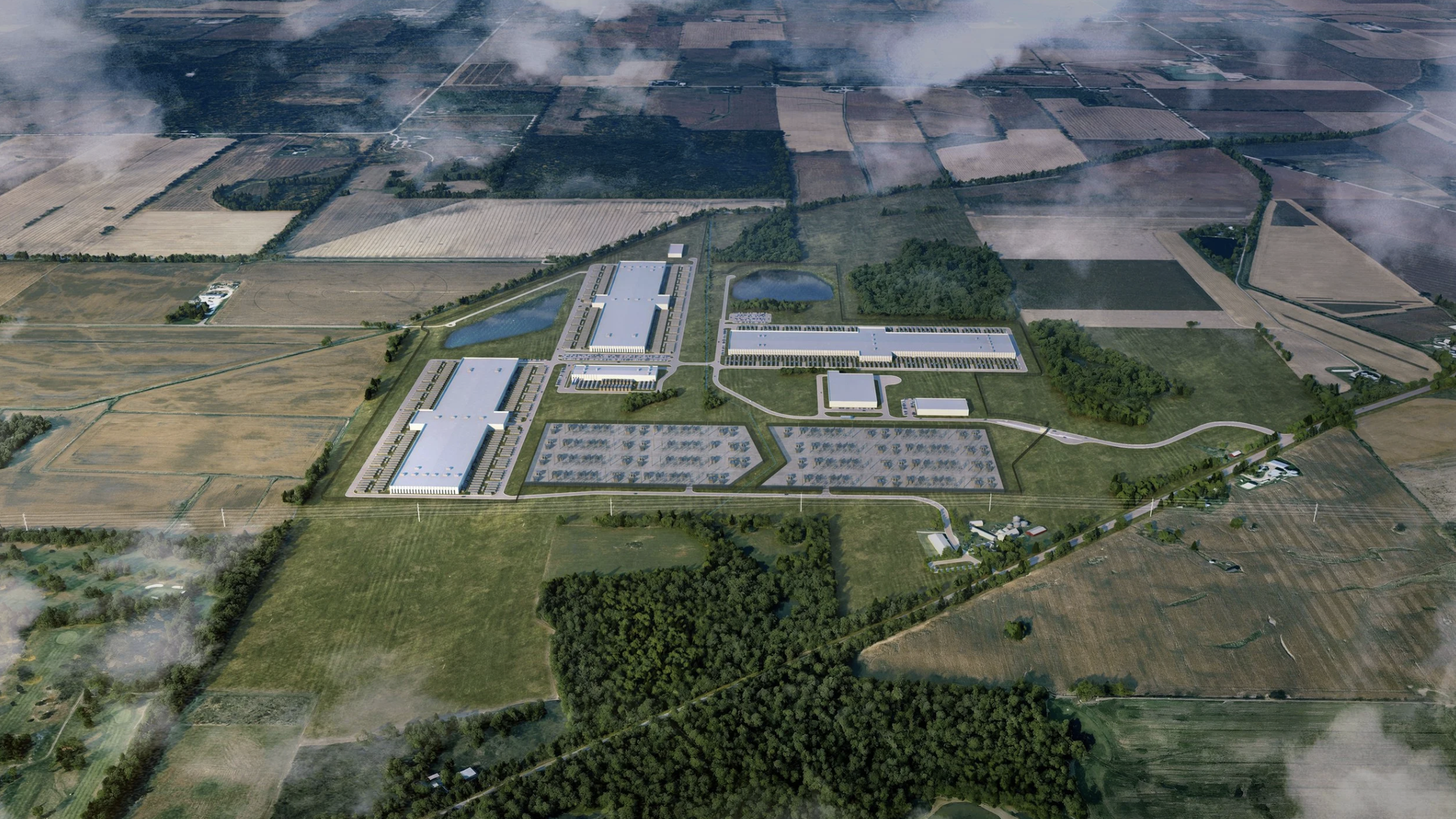 Aerial view of a large data center complex with multiple rectangular buildings, parking lots, ponds, surrounded by fields and farmland. 