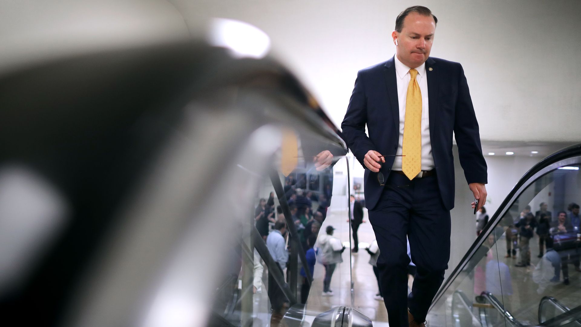 Mike Lee walks down an escalator.